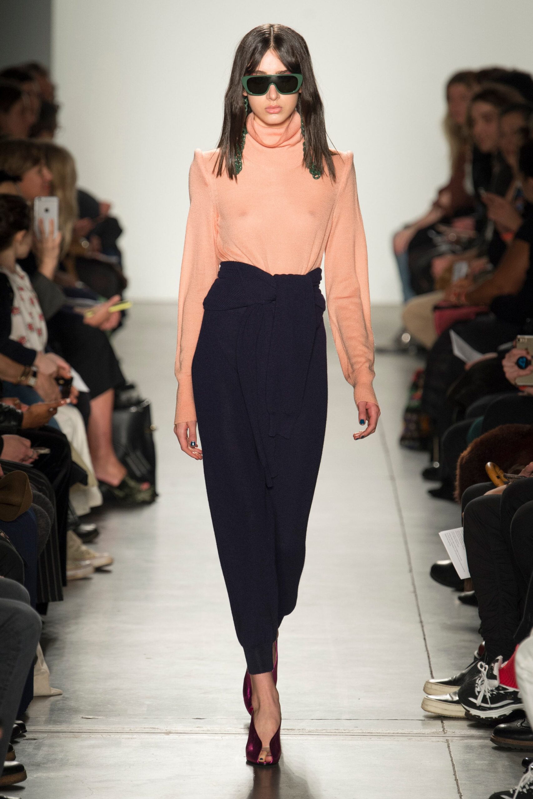 A fitted pink and navy dress with long sleeves and an asymmetric design detail.