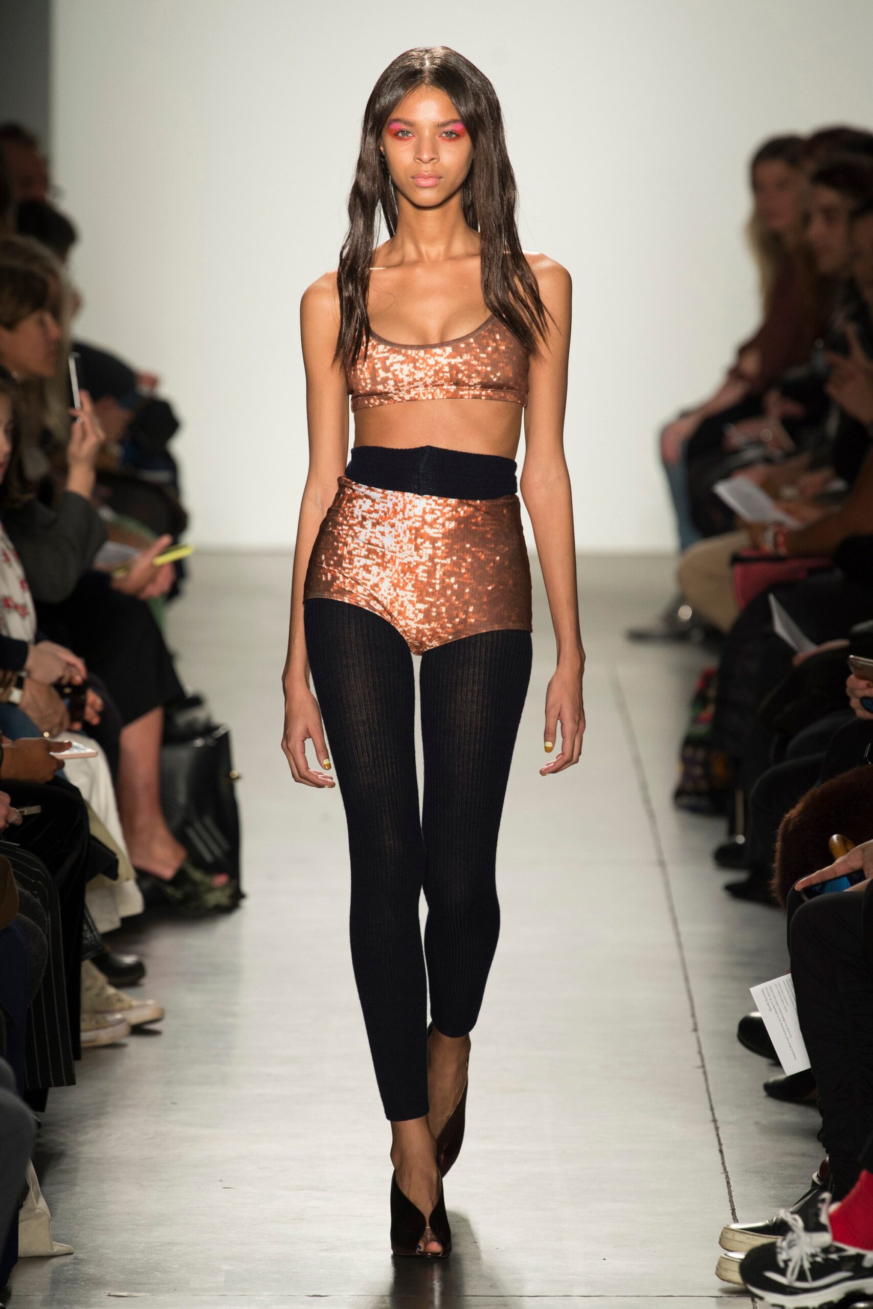 A fitted brown sequined sleeveless top paired with high-waisted black pants.