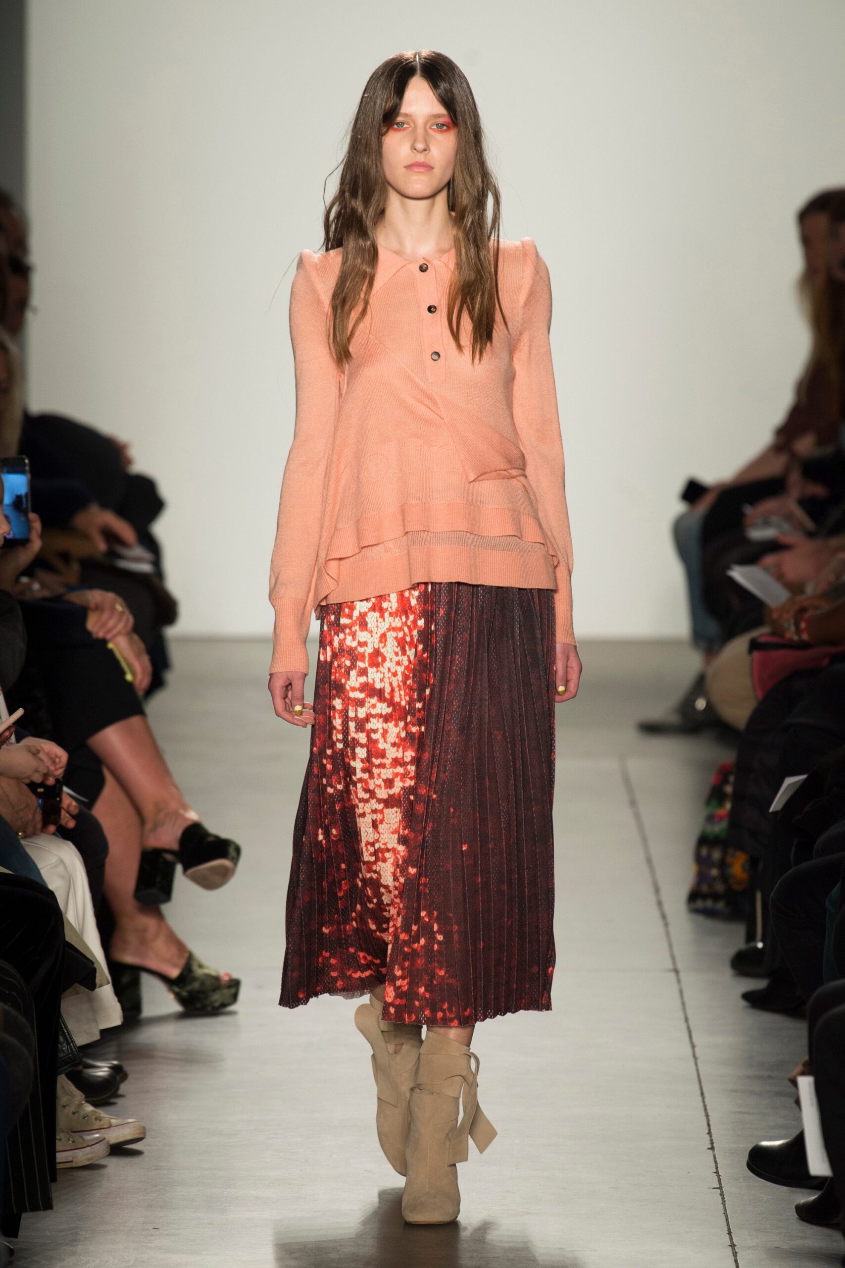 A relaxed pink top with long sleeves paired with a pleated sequined skirt.