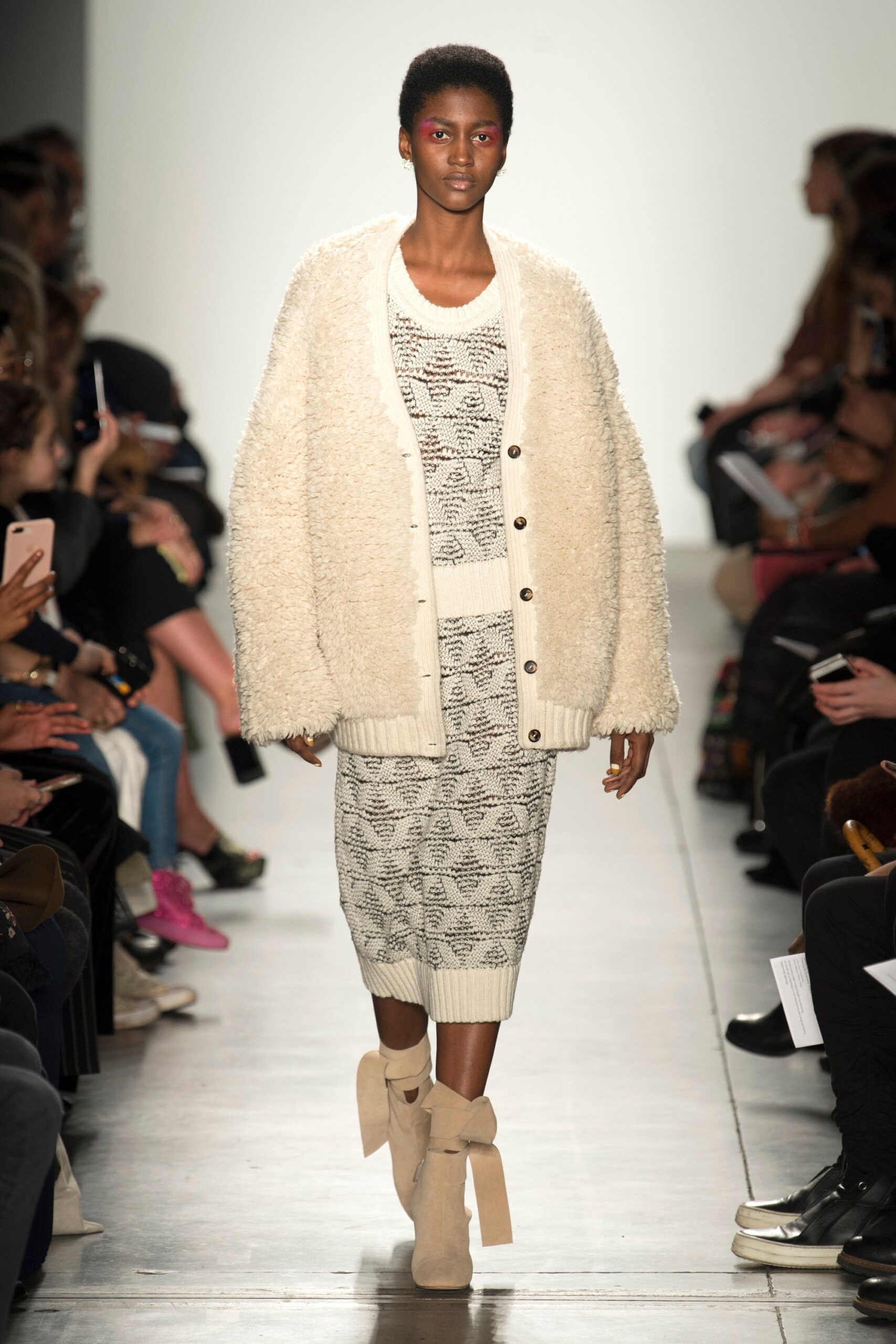 A relaxed cream knit dress layered with a matching coat featuring a collared design.