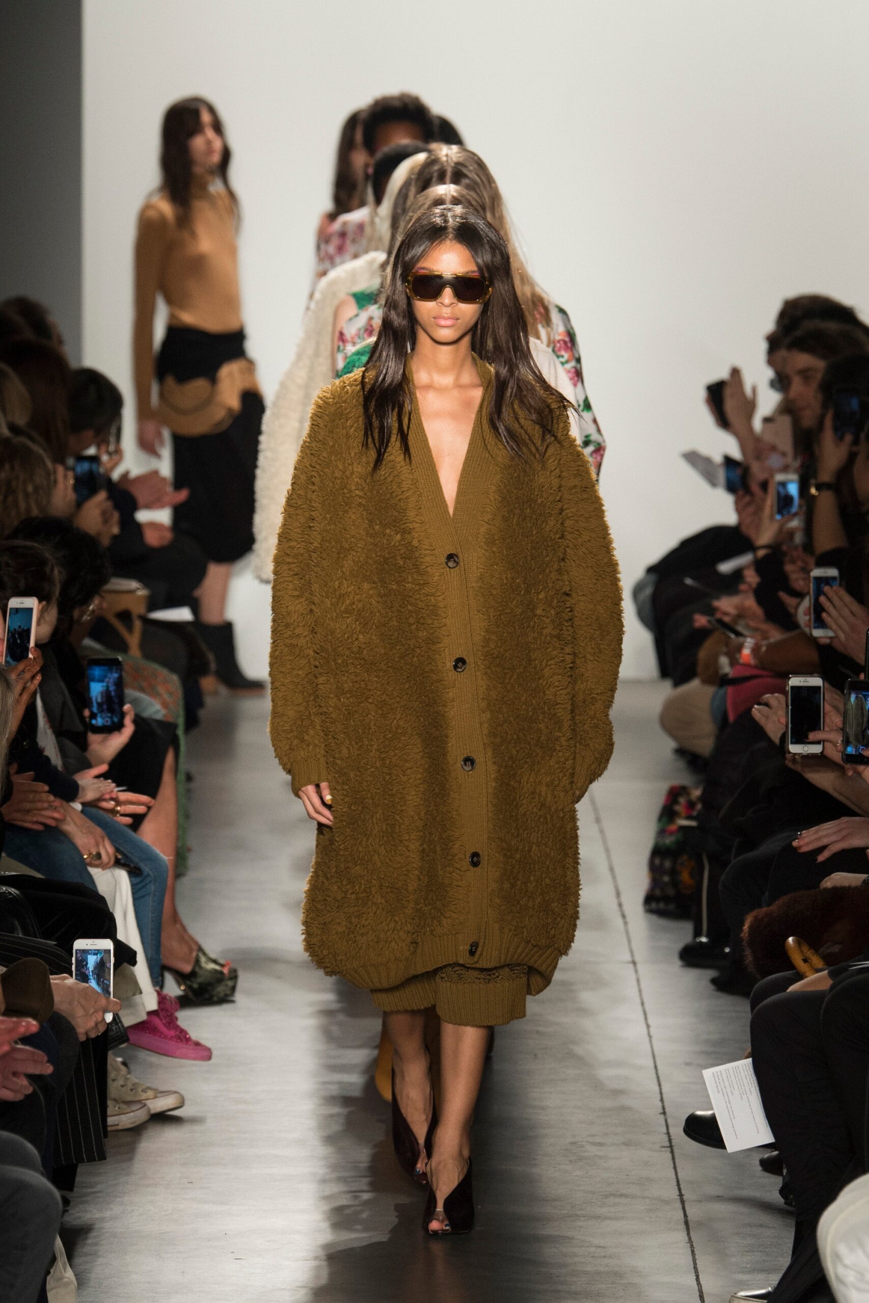 An oversized brown wool cardigan dress with long sleeves and a buttoned front.