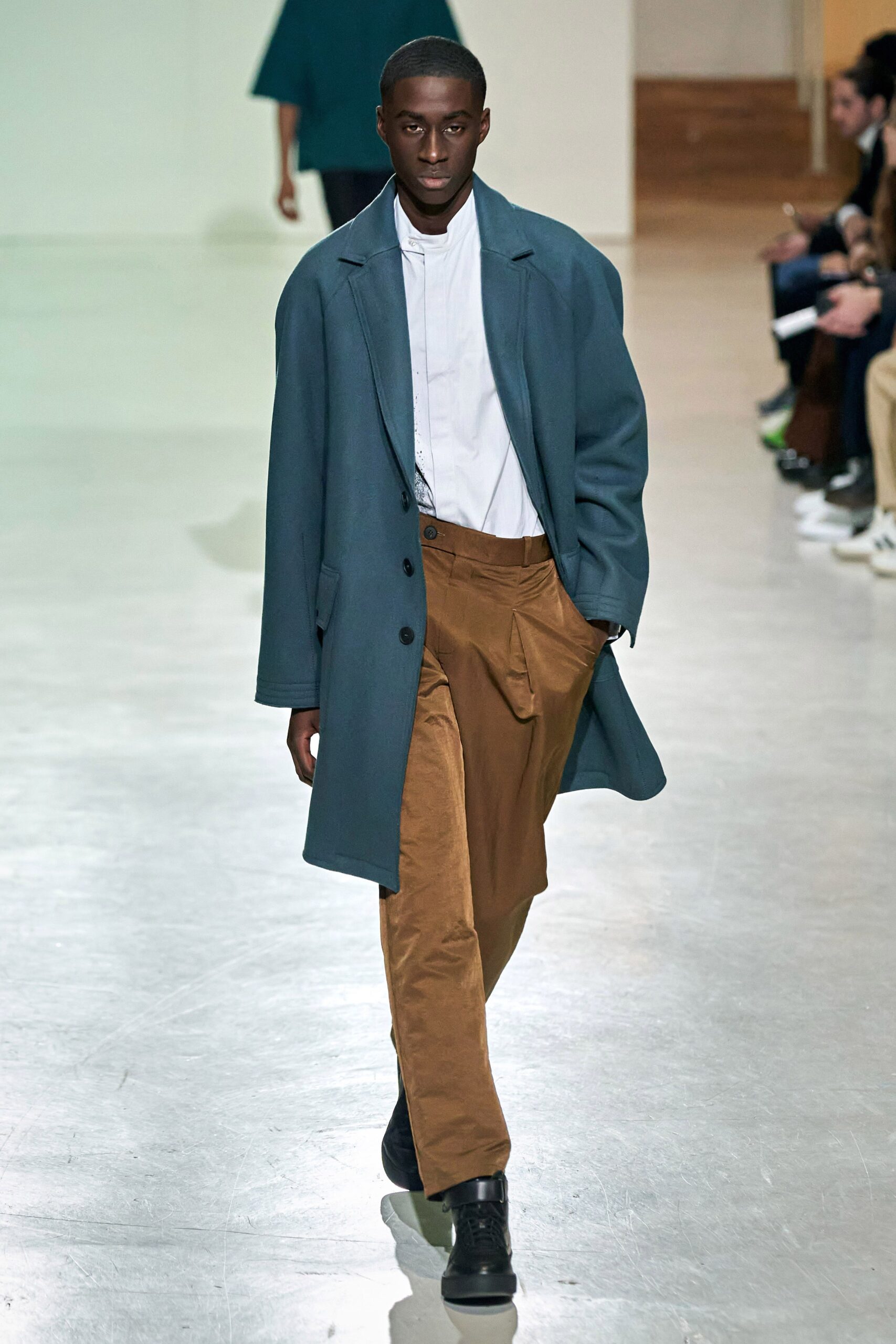 A relaxed blue coat paired with brown cotton pants featuring a collared long-sleeve design.