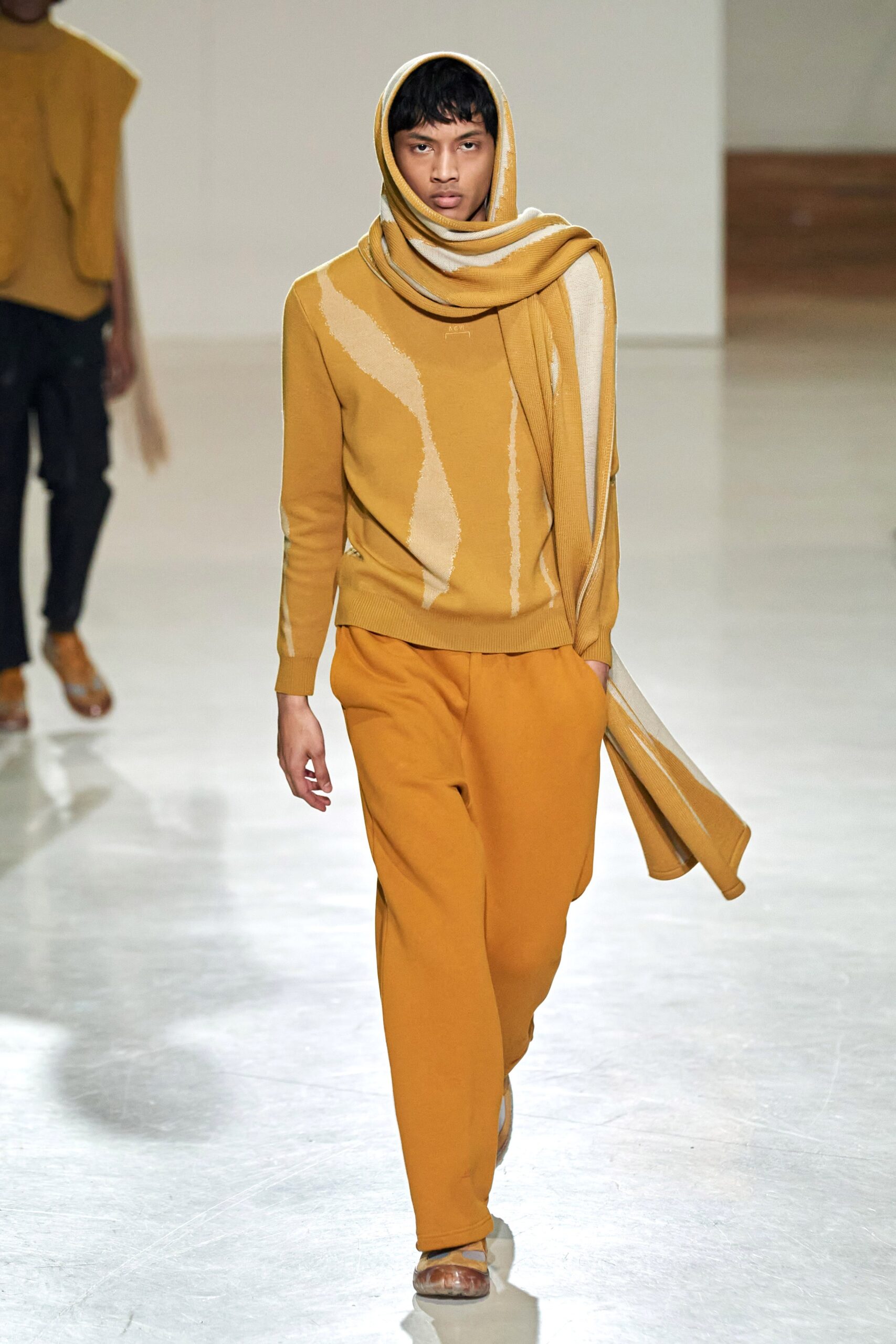 A relaxed orange and beige long-sleeve sweater paired with matching pants featuring an asymmetric design.