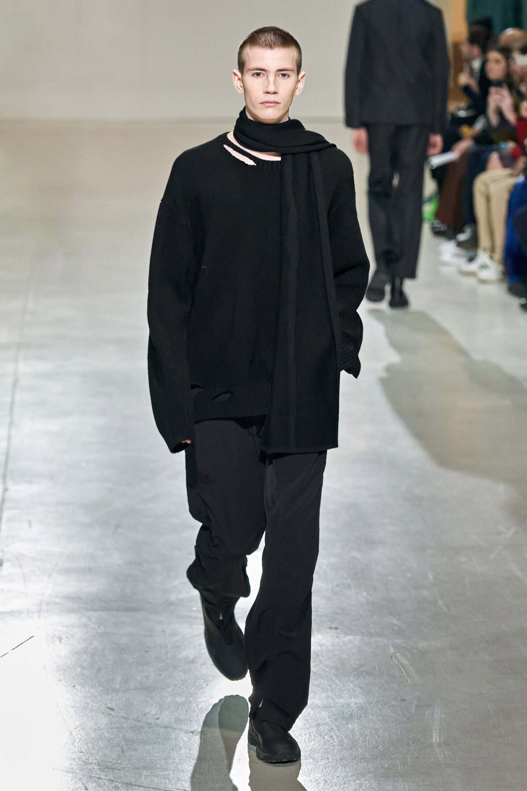 A relaxed black wool sweater with long sleeves paired with matching black pants.