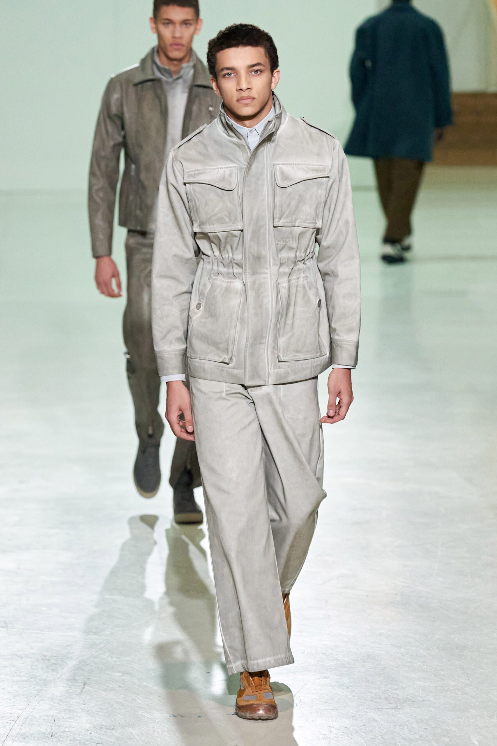 A fitted gray leather jacket with a collared neckline paired with matching pants.