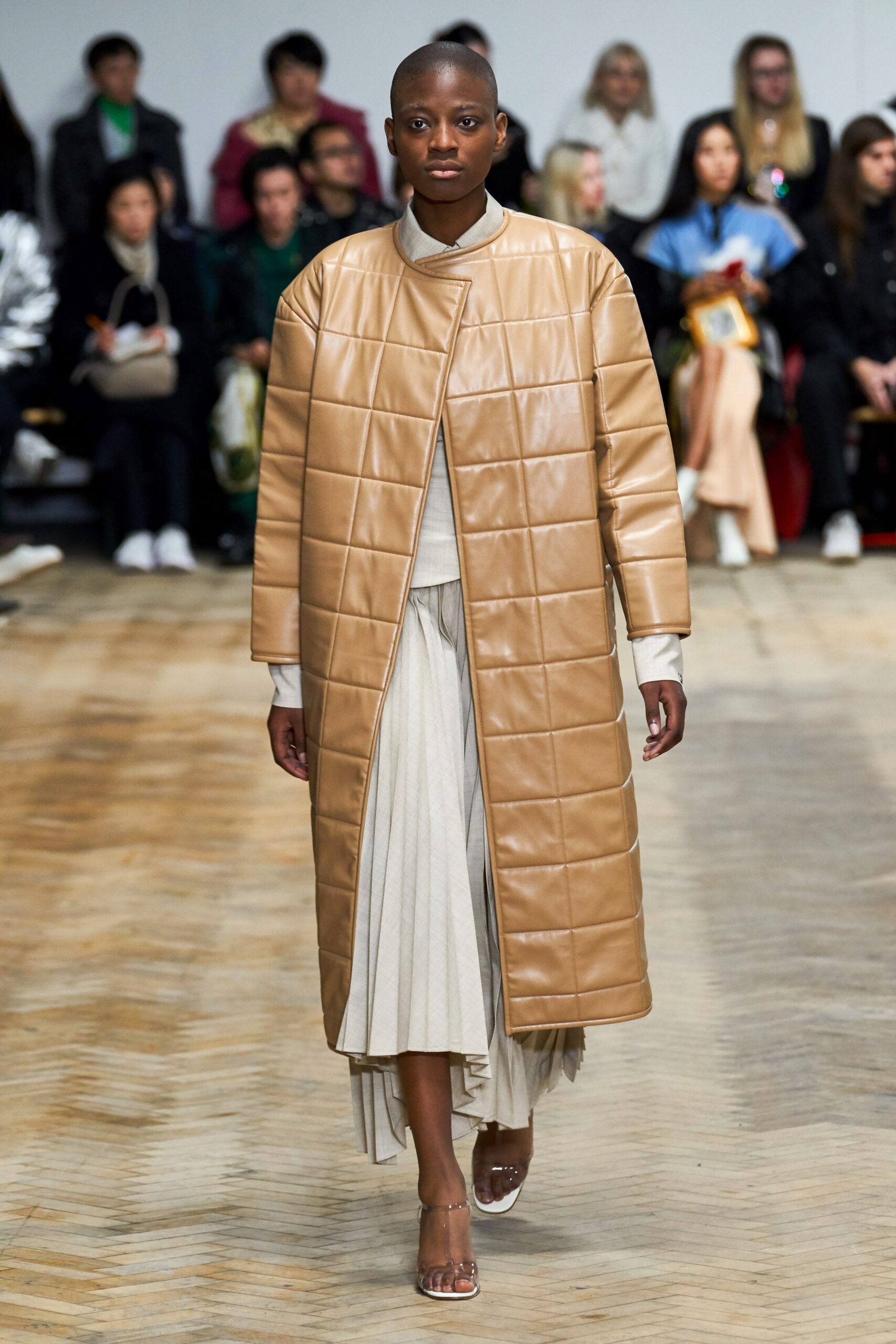 beige leather quilted coat and white pleated dress
