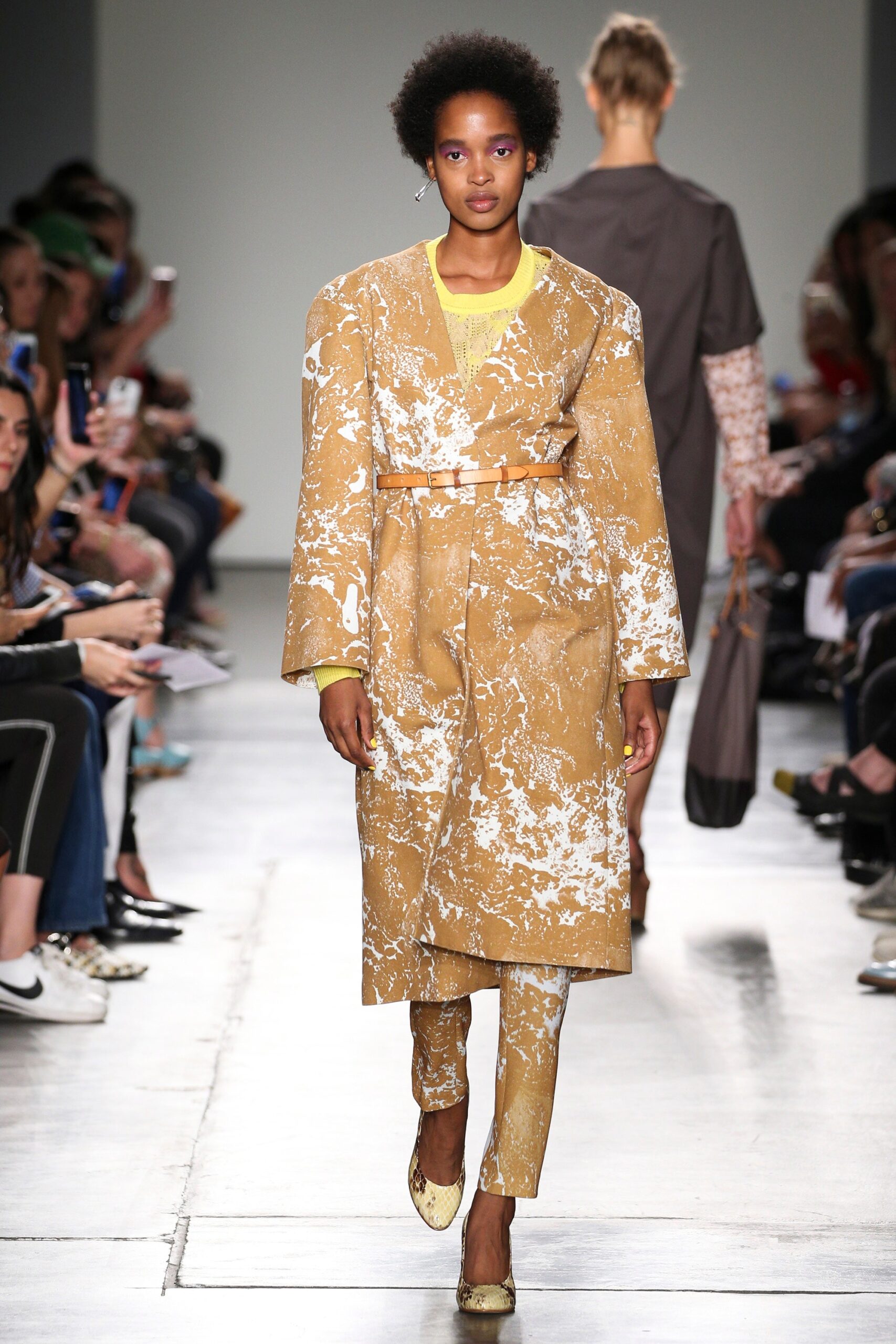 A fitted brown and white printed coat paired with matching pants and a collared long-sleeve top.