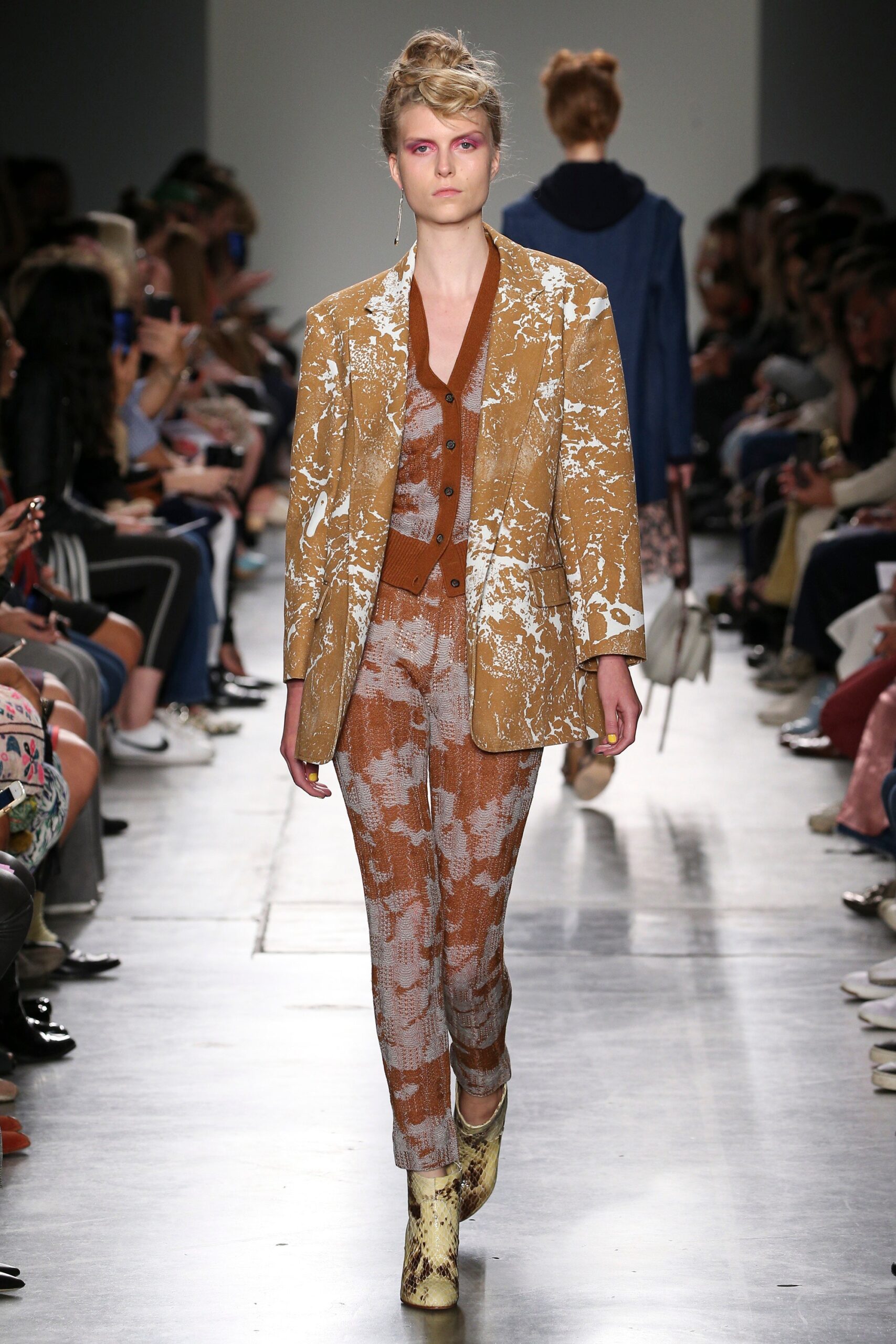 A fitted brown and beige printed suit with a collared long-sleeve jacket.
