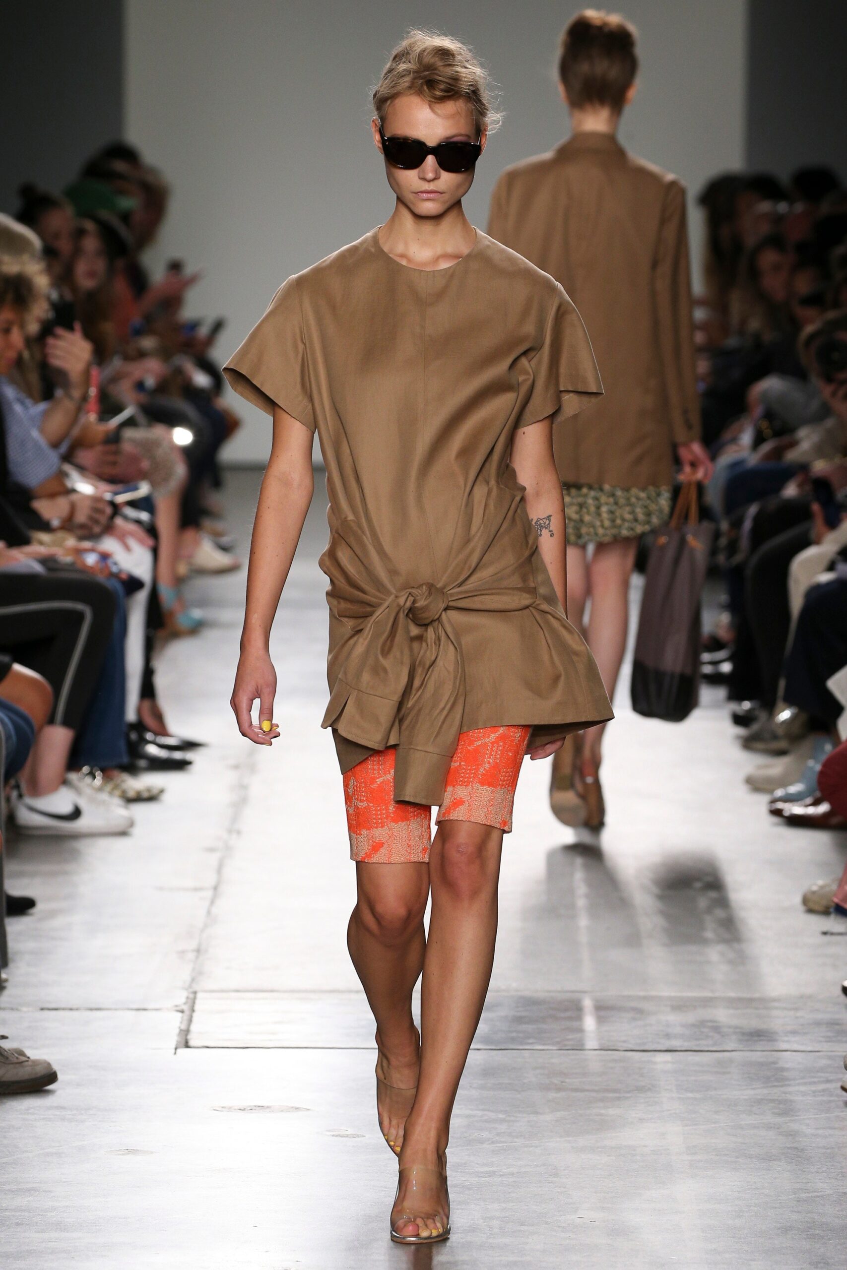 A relaxed brown cotton dress with short sleeves and an asymmetric design.