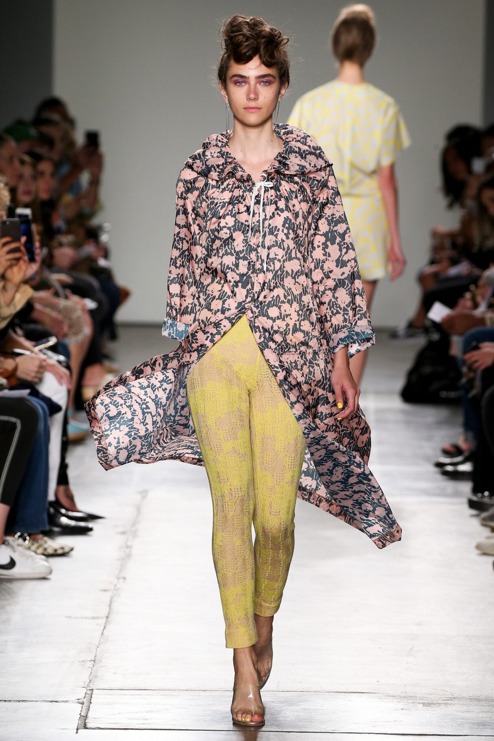 A relaxed pink printed coat paired with yellow pants, featuring a long-sleeve and collared design.