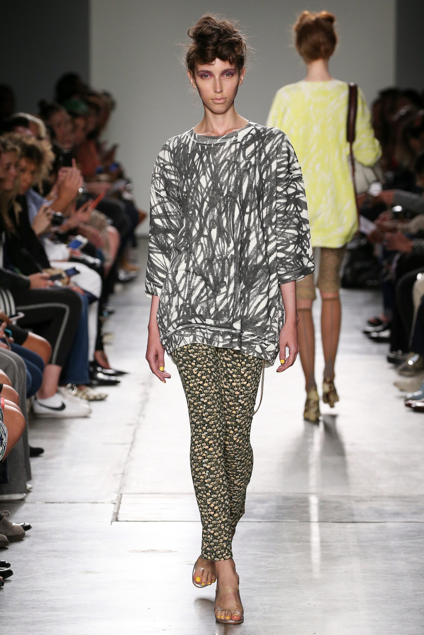 A relaxed gray printed top paired with yellow patterned pants for a stylish runway look.