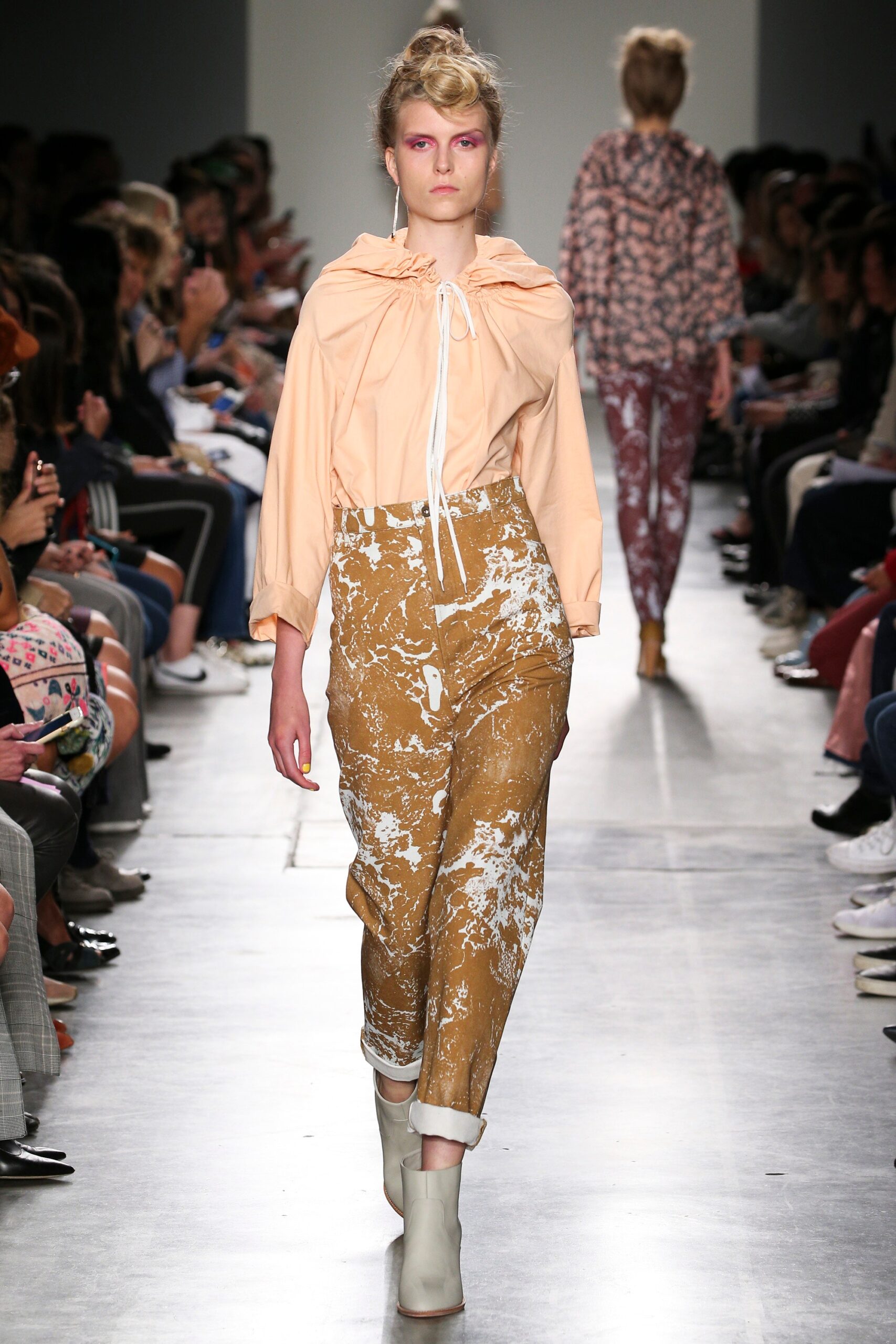 A relaxed peach cotton top with long sleeves paired with printed brown pants.