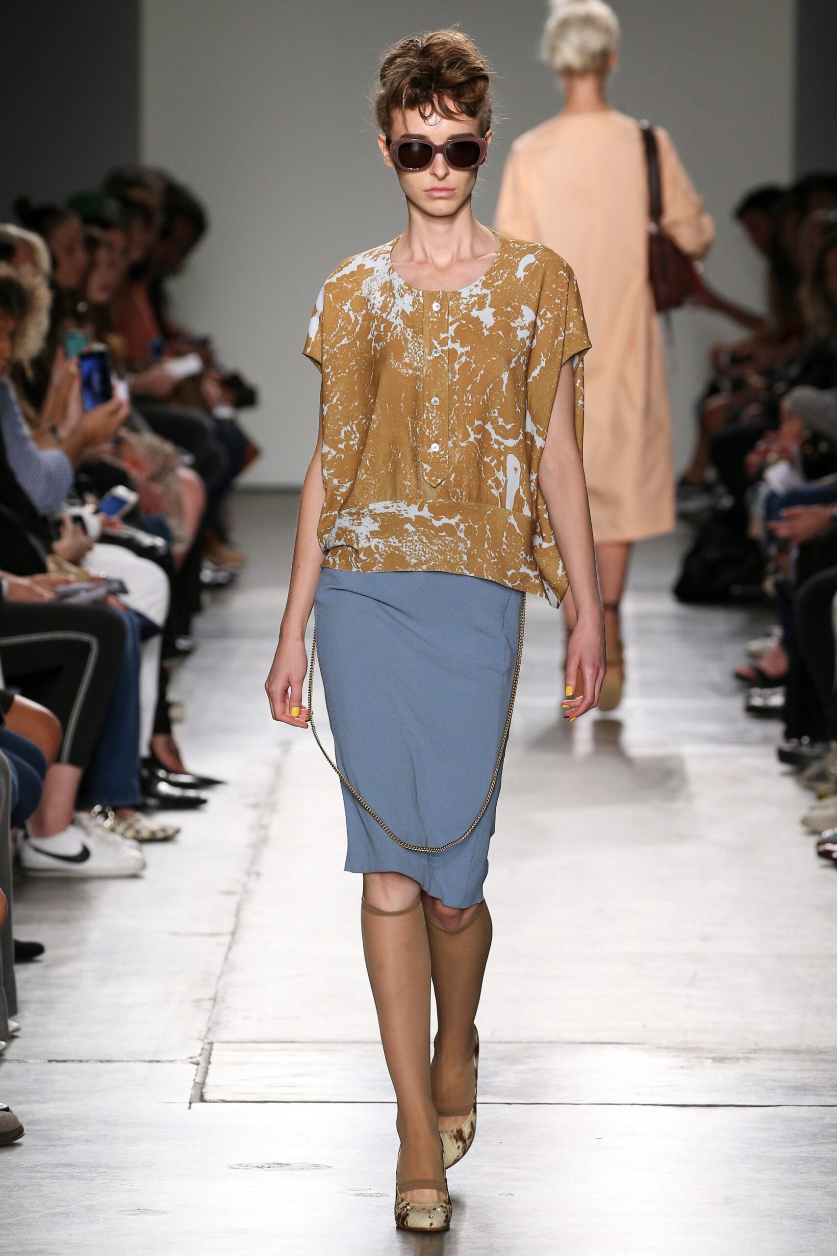 A relaxed brown printed top paired with a fitted blue pencil skirt.