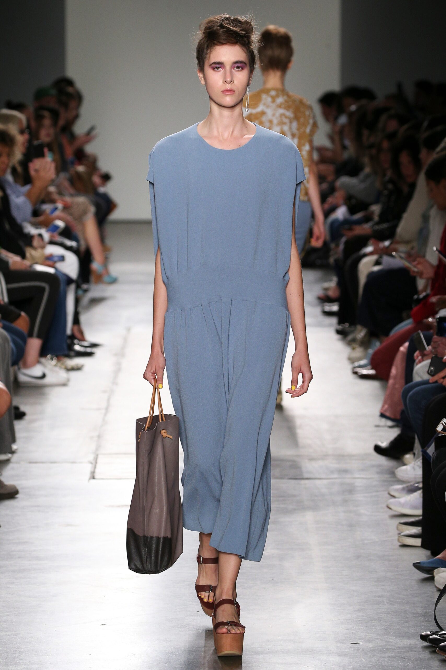 A relaxed blue cotton jumpsuit with short sleeves and a V-neckline, featuring a wide-leg silhouette.