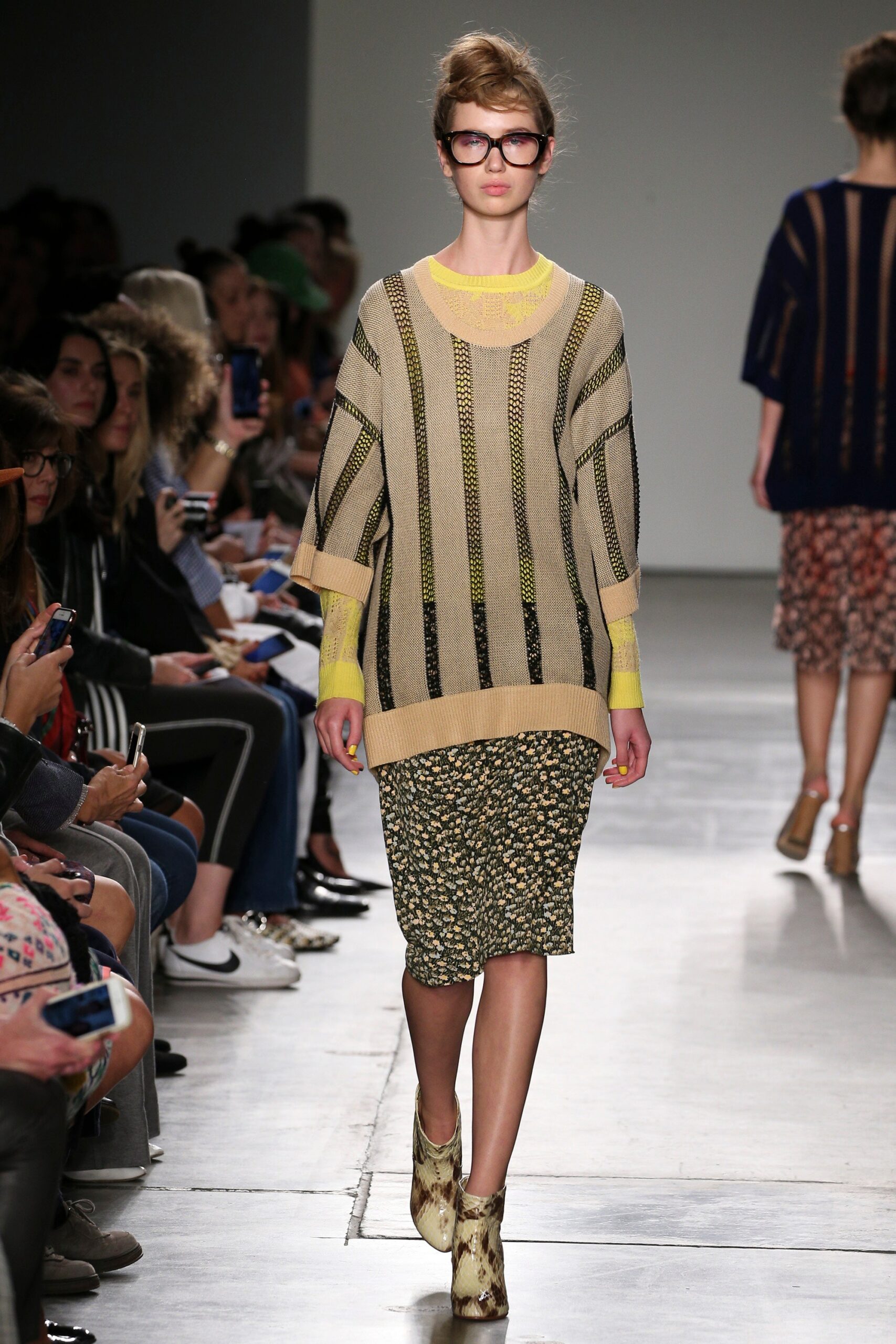 A relaxed beige striped sweater paired with a floral skirt, featuring long sleeves and a crew neckline.