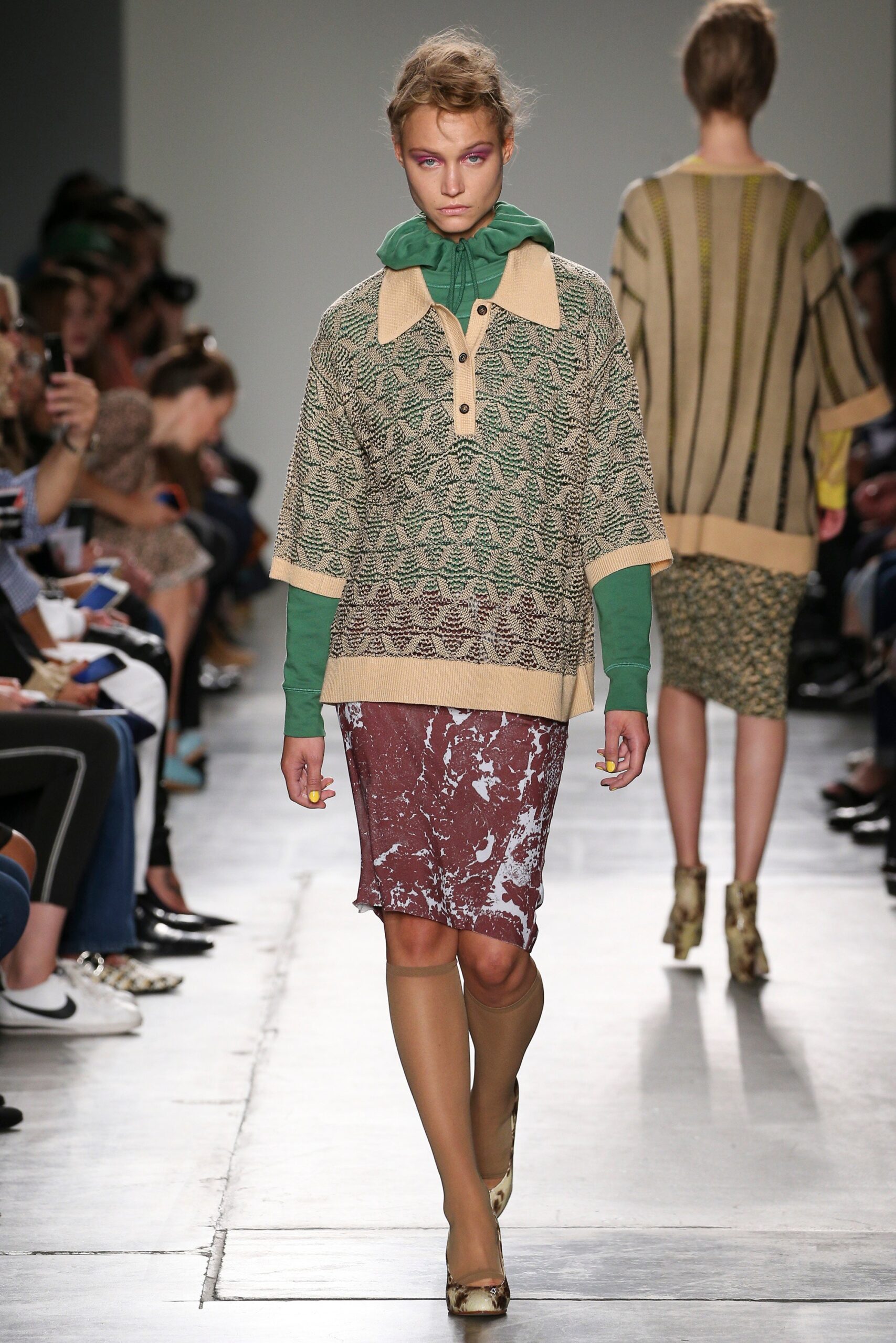 A relaxed beige top with a collared design paired with a layered skirt in earthy tones.