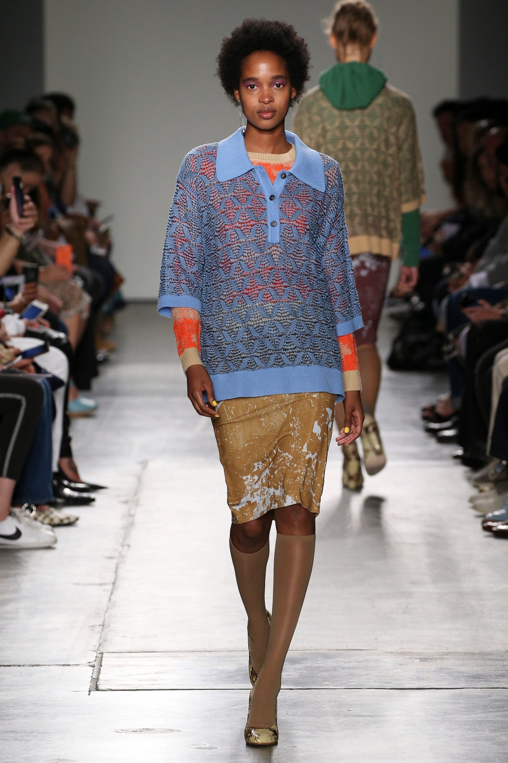 A relaxed blue printed sweater with a collared neckline paired with an asymmetric skirt.