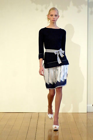 black fitted top with white pleated skirt