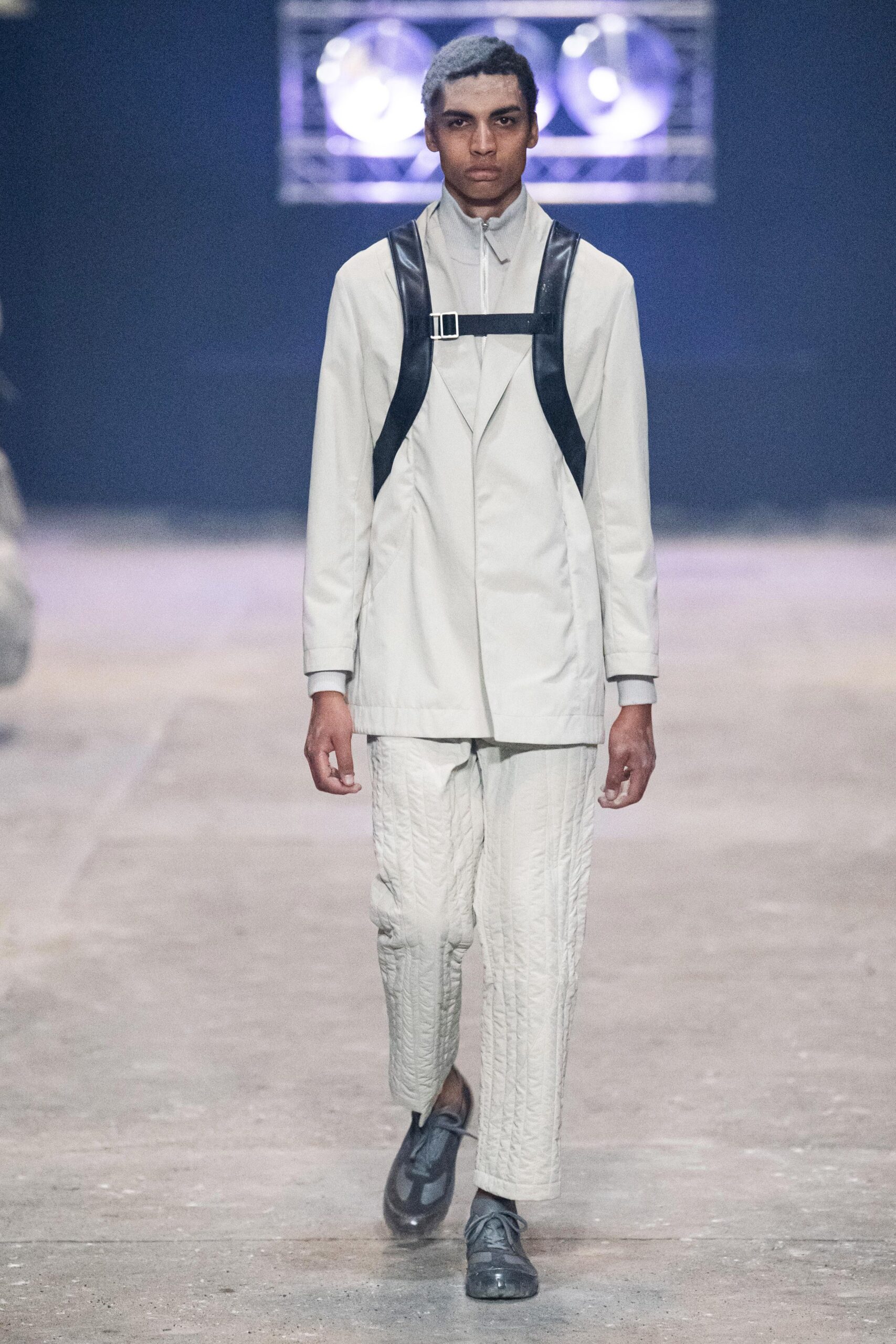 A fitted white jacket with a collar and long sleeves paired with matching pants.