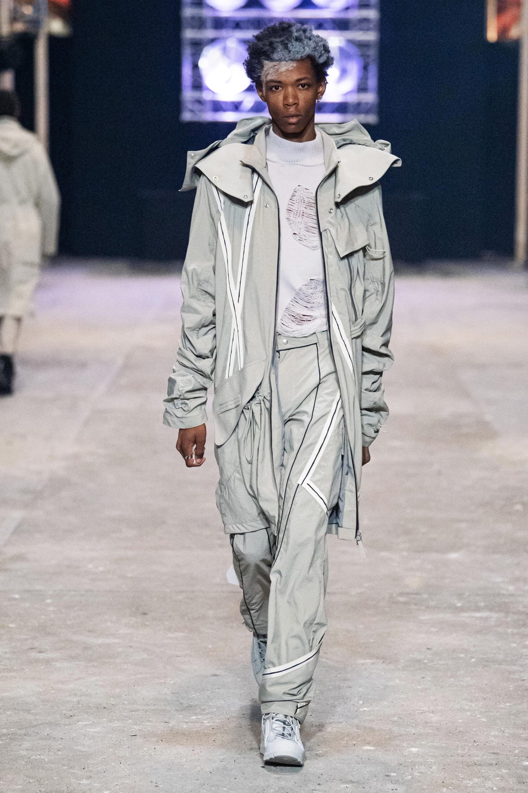 A relaxed gray hooded jacket paired with matching pants featuring zippered details.