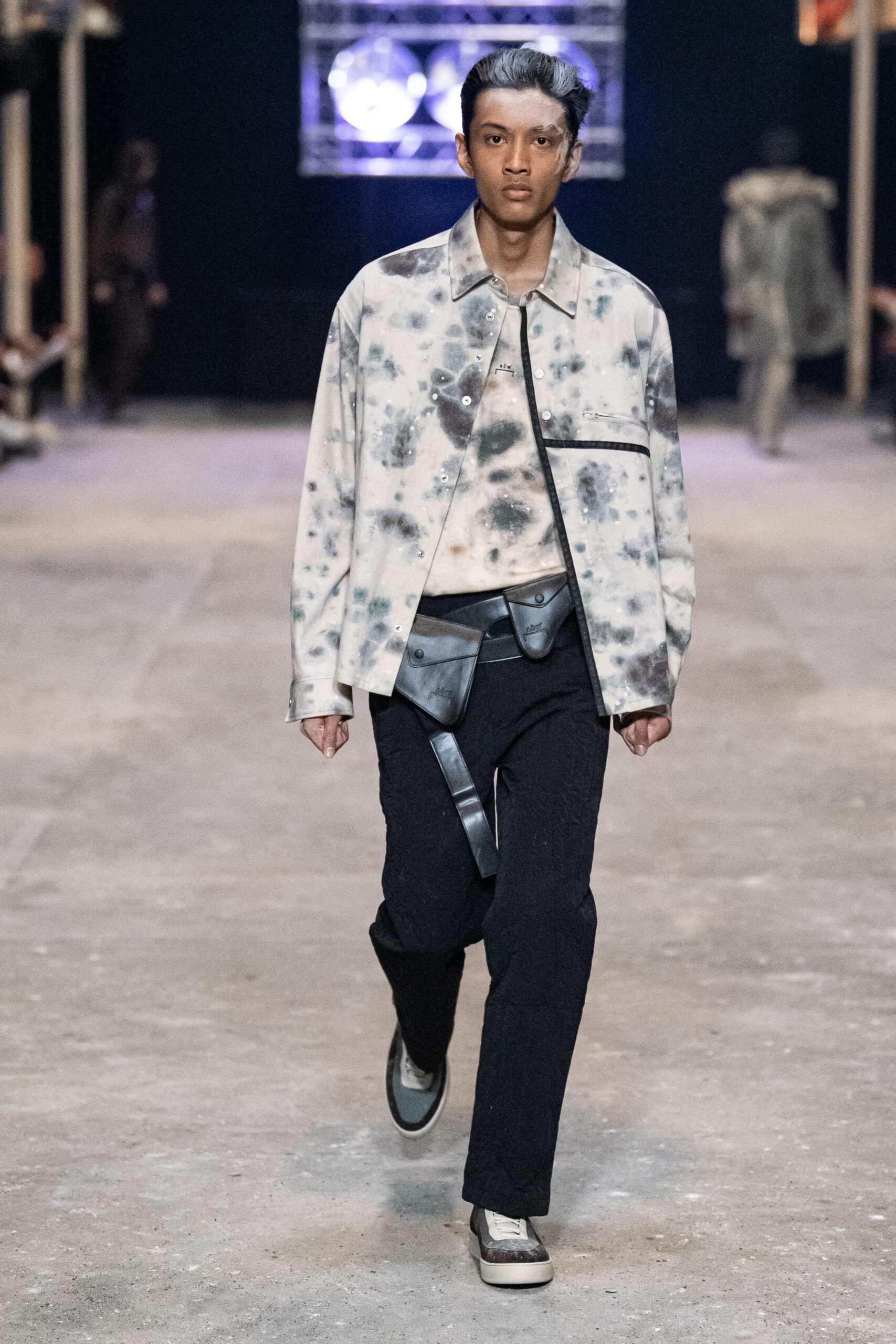 A relaxed black and white printed jacket paired with black pants for a casual look.