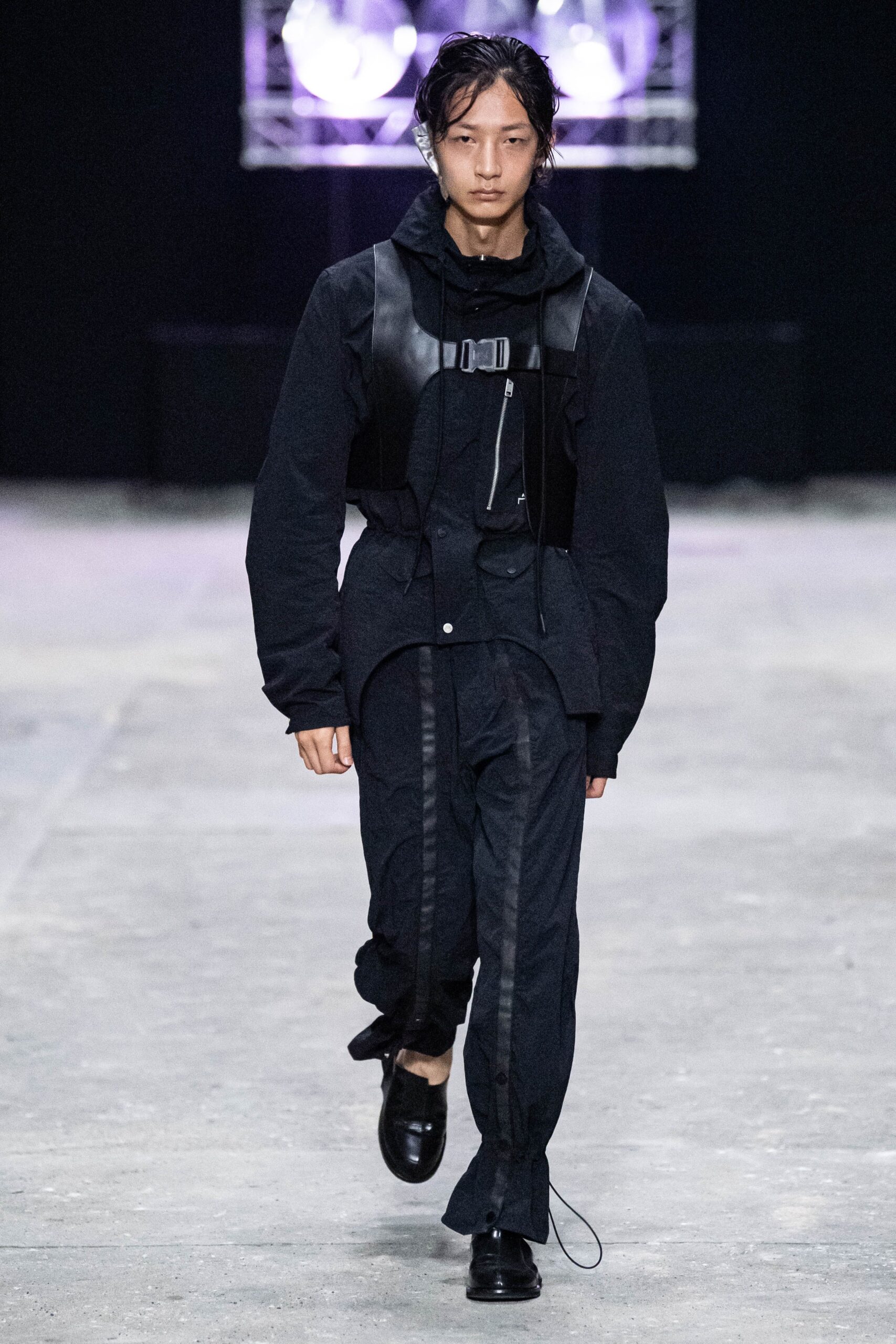 A relaxed black jacket with long sleeves and matching pants featuring zippered details.