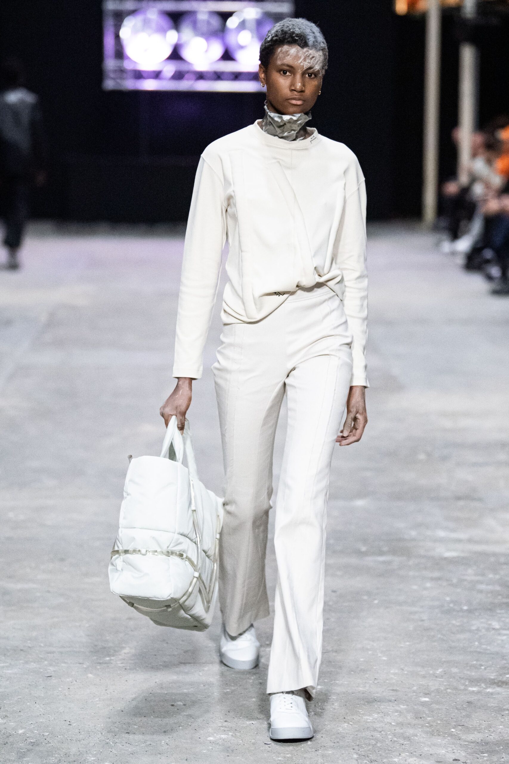 A fitted white cotton long-sleeve top with a high neckline paired with straight-leg pants.