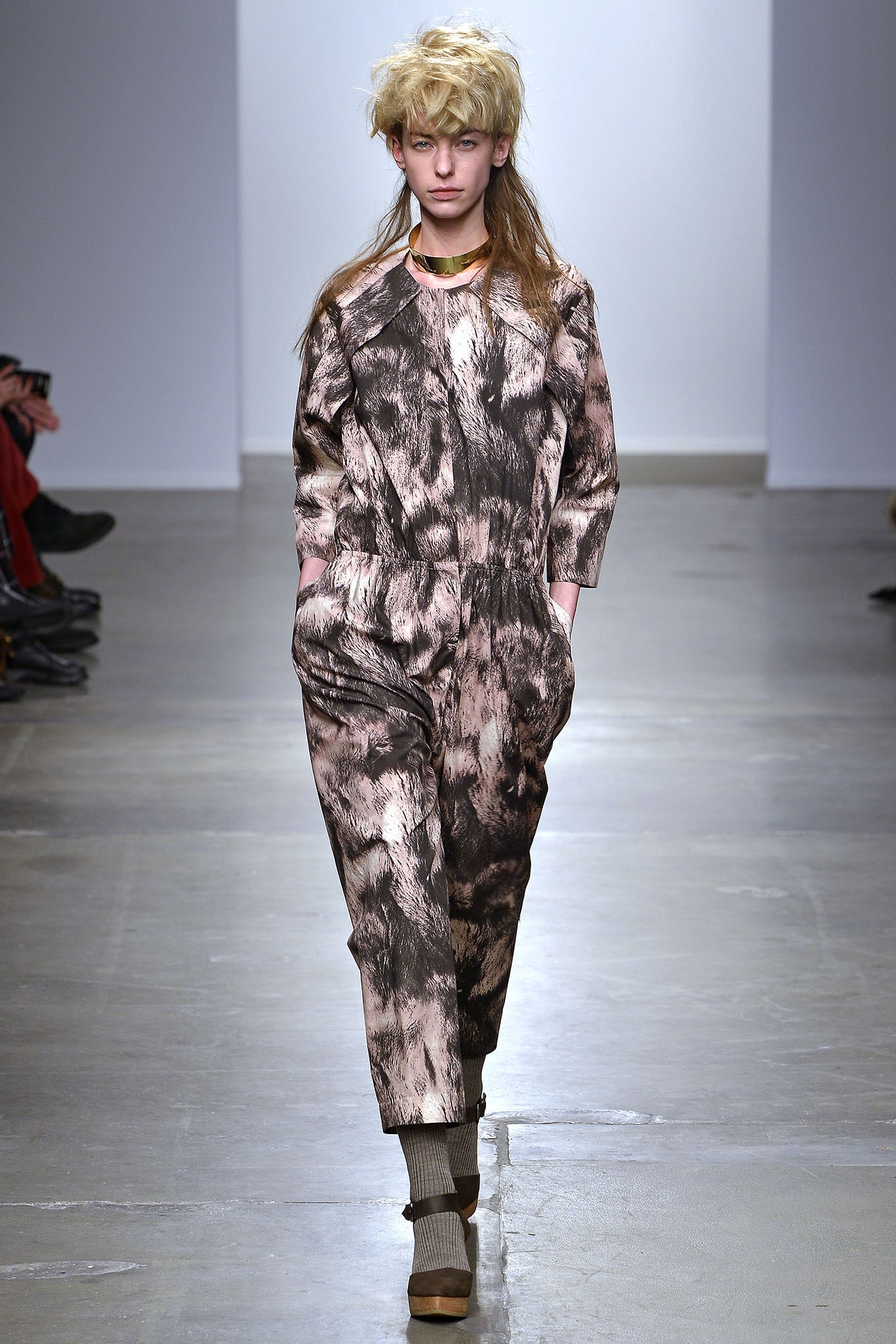 A relaxed brown and cream printed jumpsuit with long sleeves and a collared neckline.