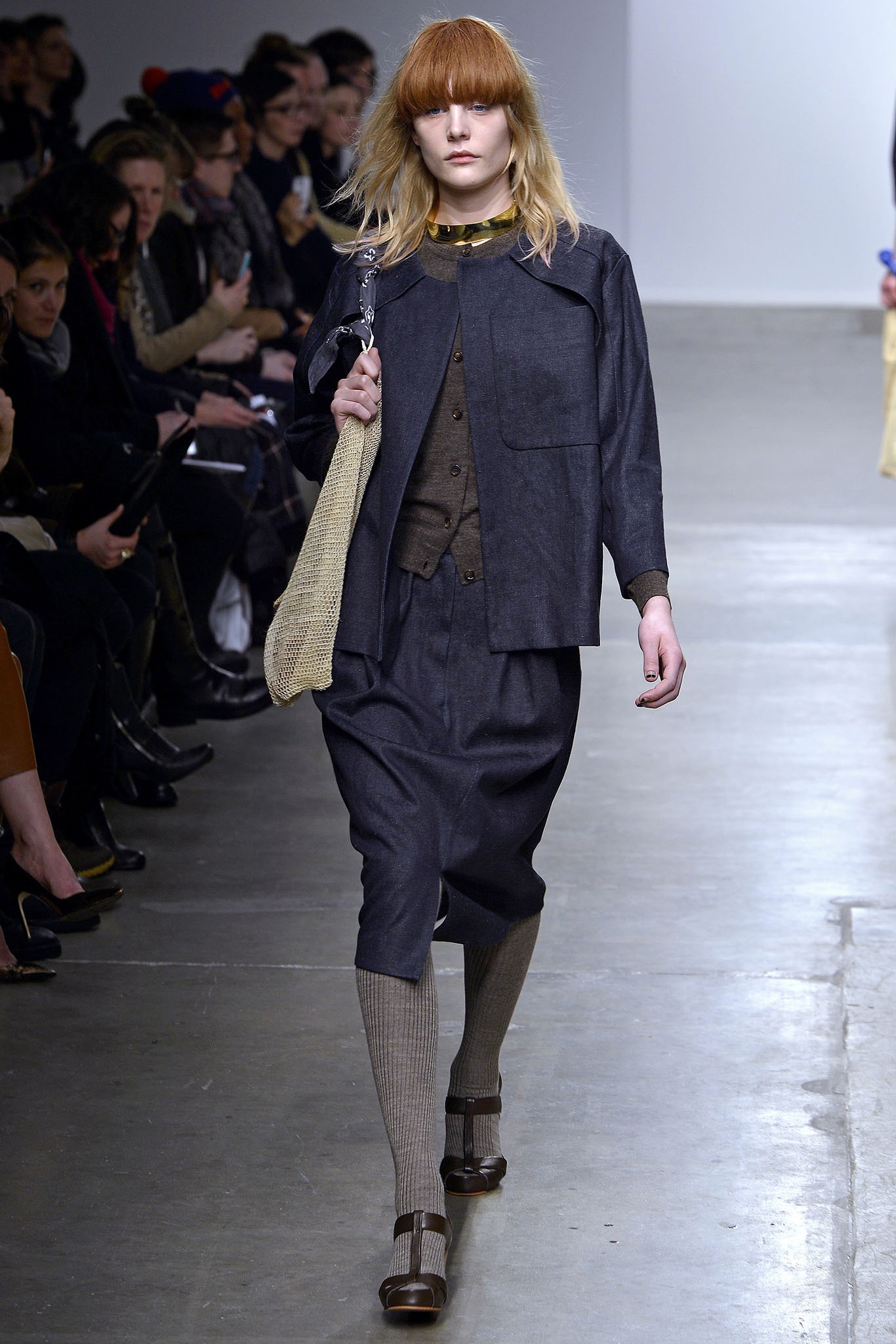 A relaxed blue denim dress with long sleeves and an asymmetric design detail.