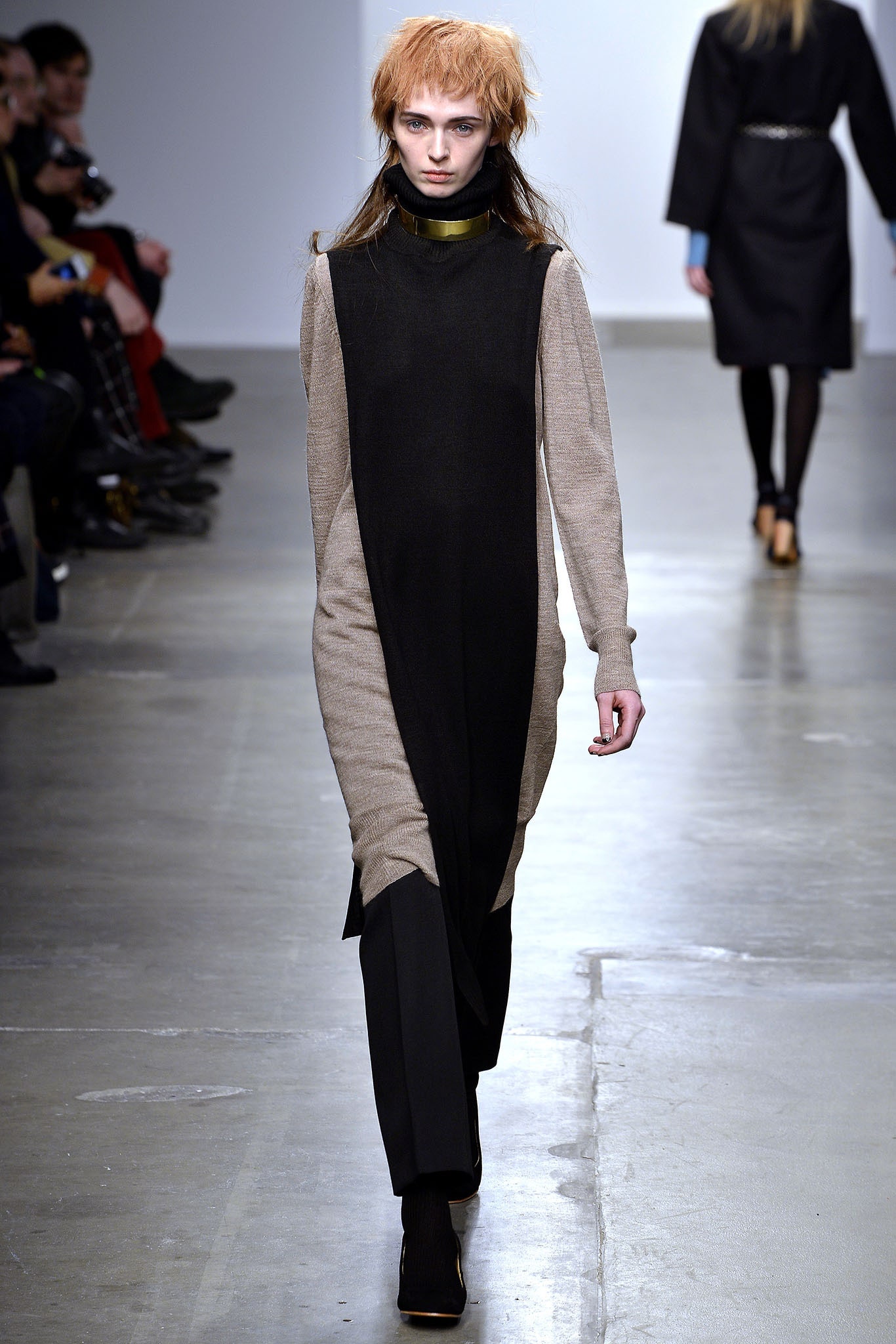 A relaxed, long-sleeve dress featuring an asymmetric design in black and beige wool.