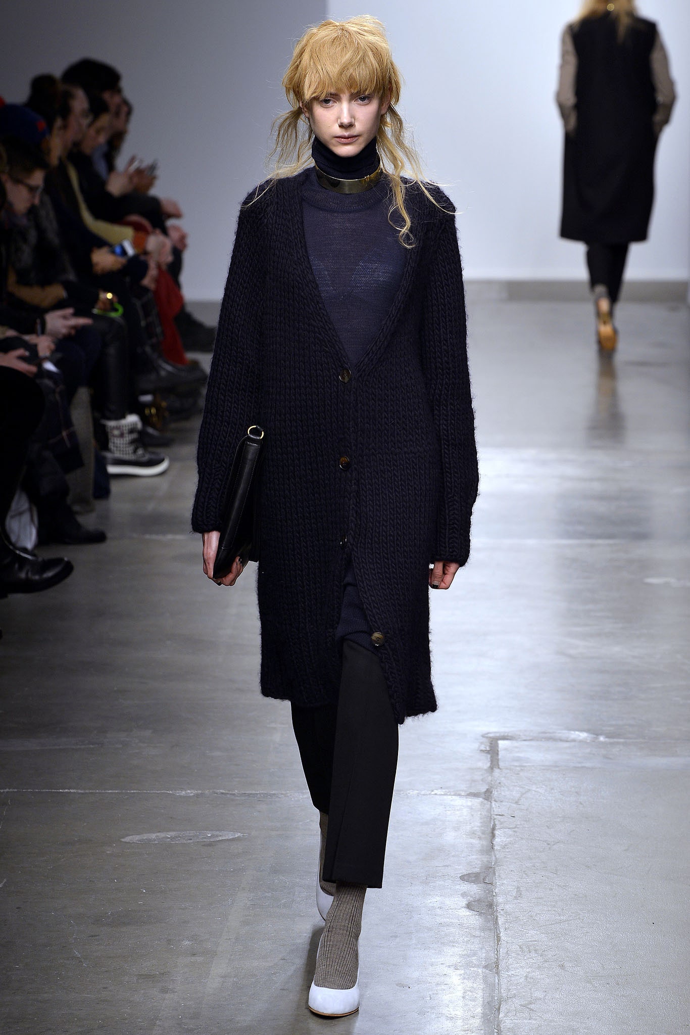 A relaxed black wool cardigan with long sleeves, buttoned front, and straight-leg pants.