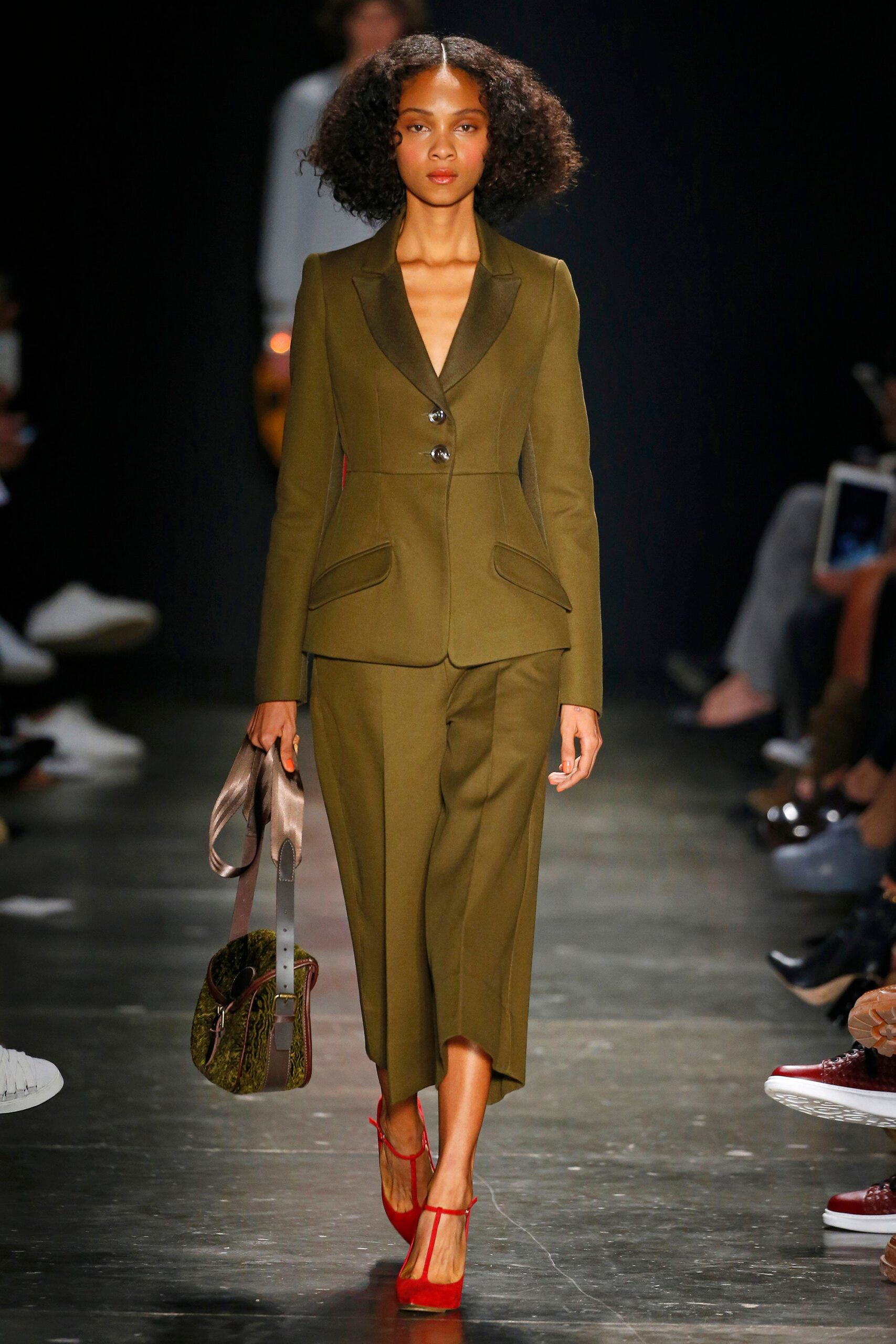 A tailored olive suit with long sleeves, a collared neckline, and wide-leg trousers.