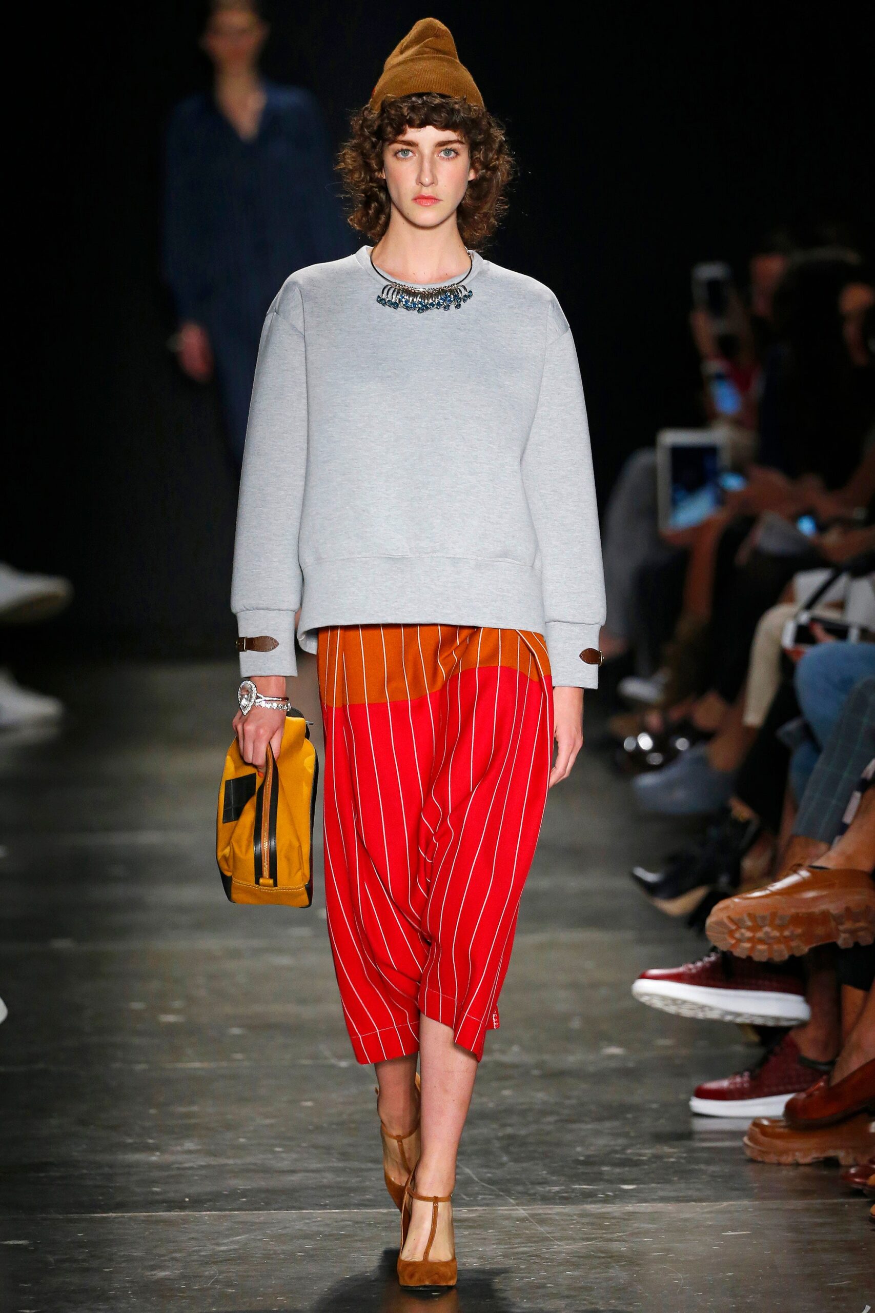 A relaxed gray long-sleeve sweater paired with striped red pants for a casual look.