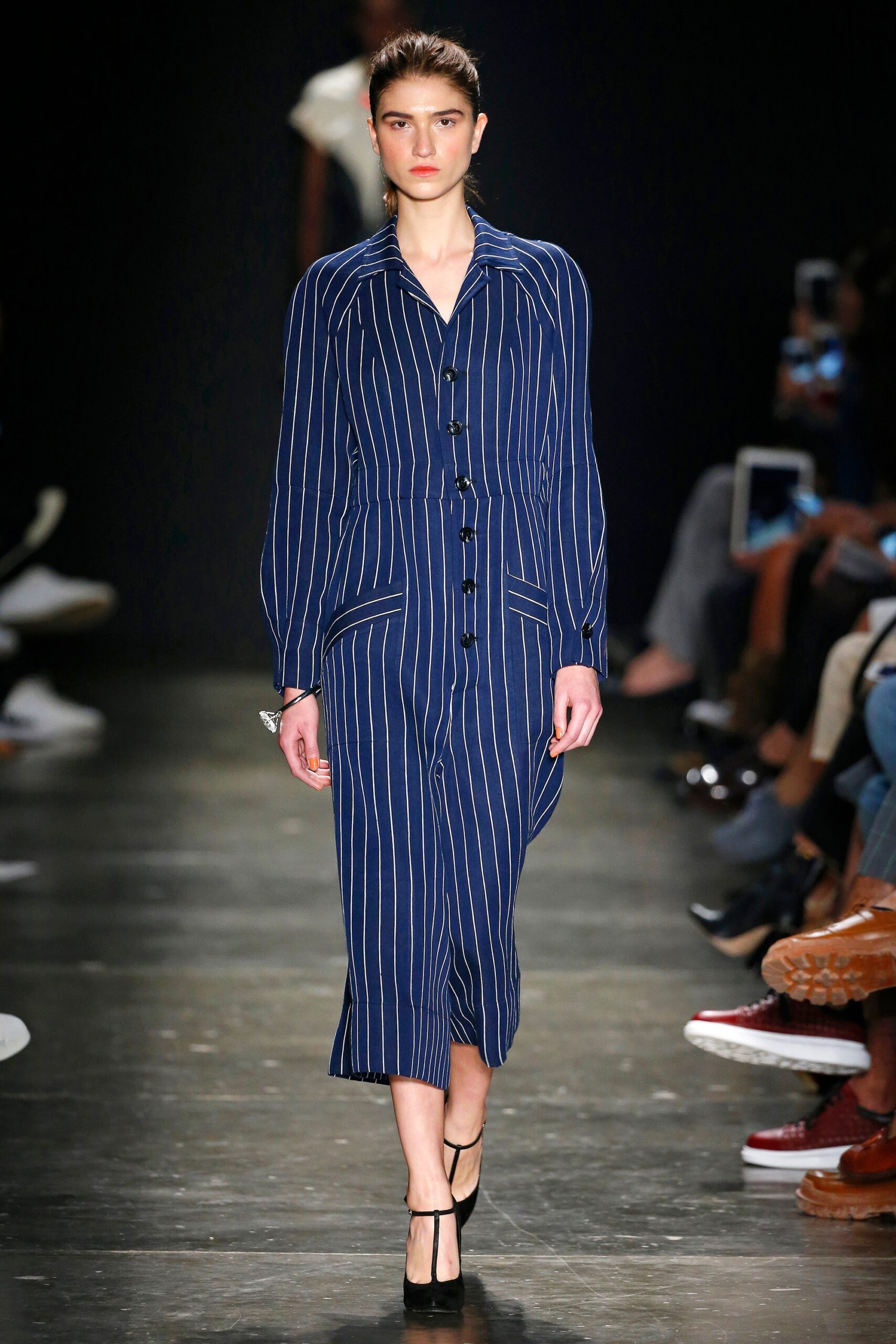 A fitted blue striped dress with long sleeves and a collared neckline, featuring button details.