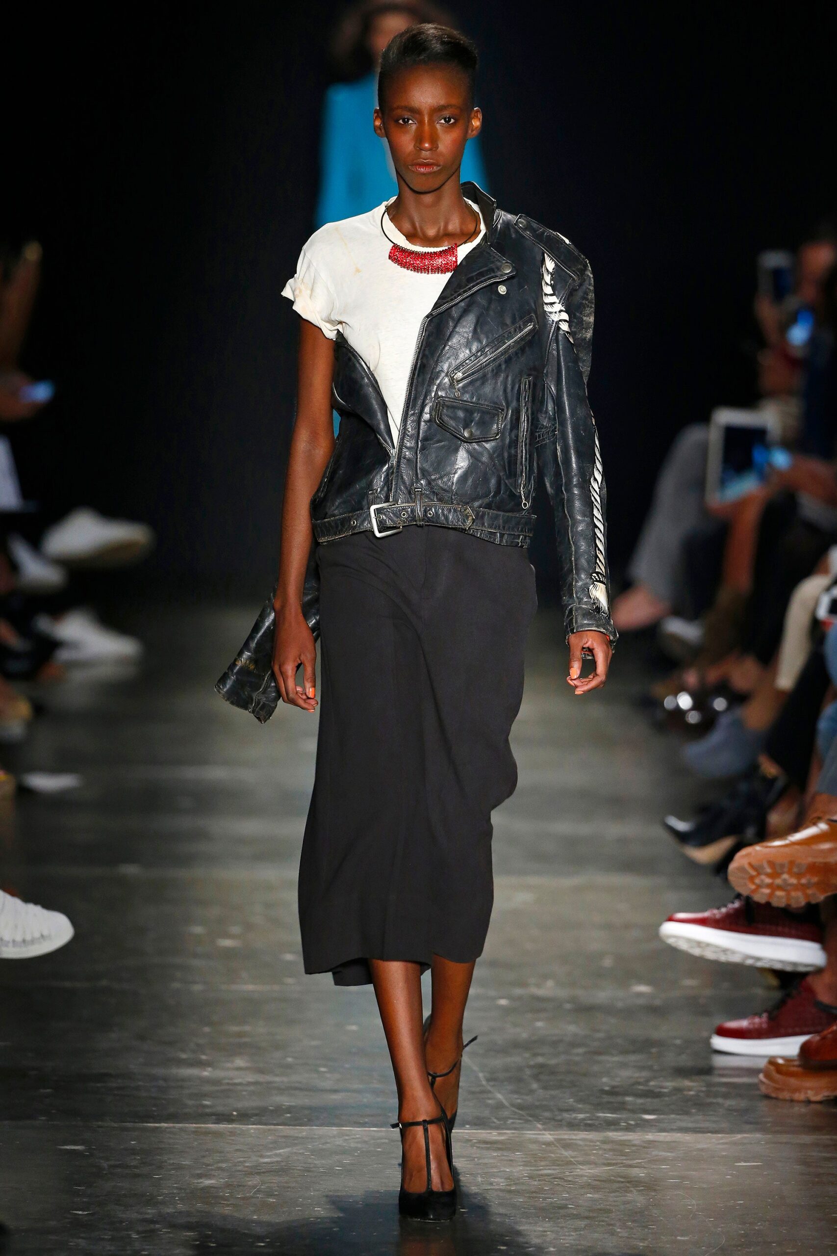 A fitted black dress paired with a short-sleeve white top and an asymmetric leather jacket.