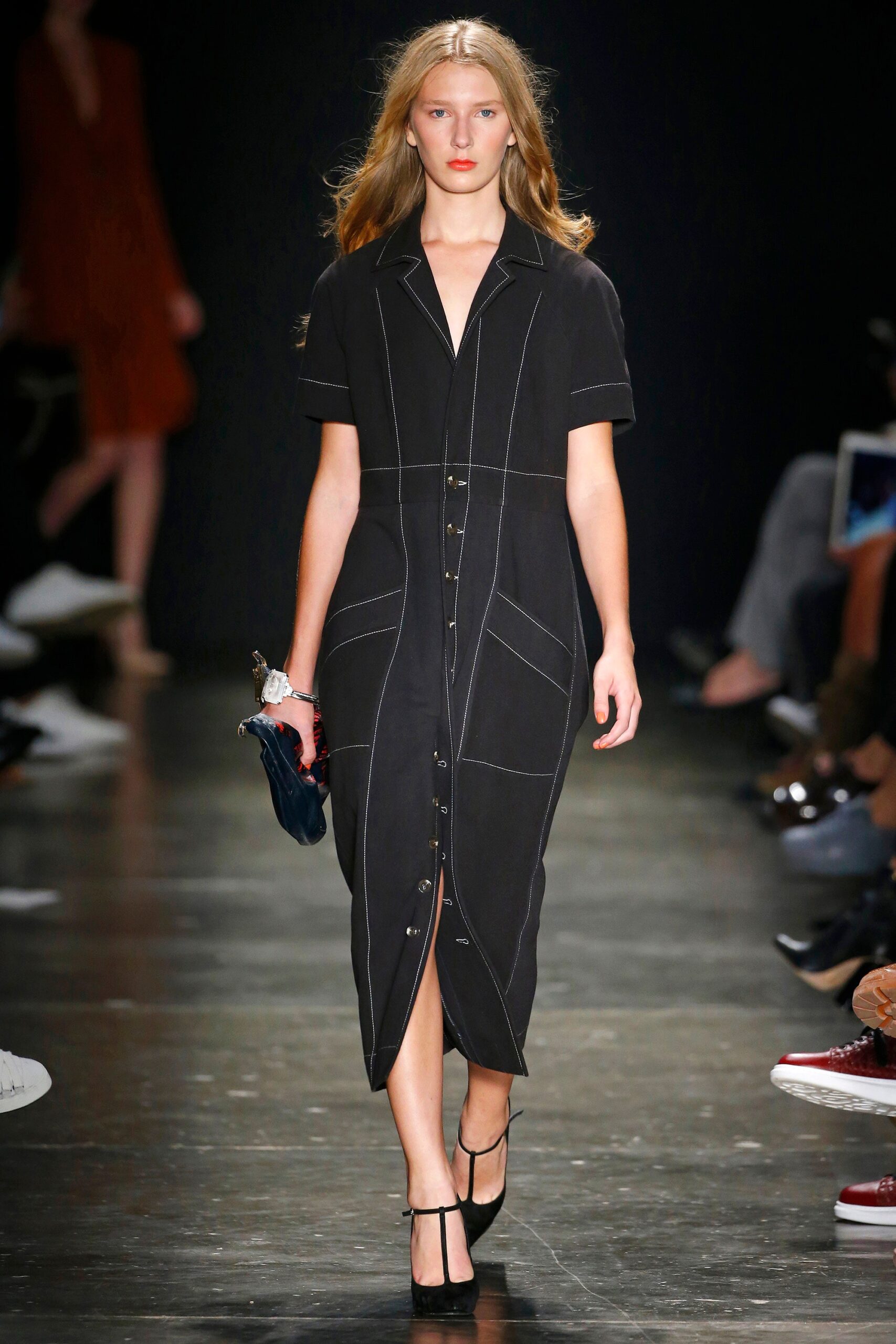A fitted black cotton dress with short sleeves, a collared neckline, and buttoned details.