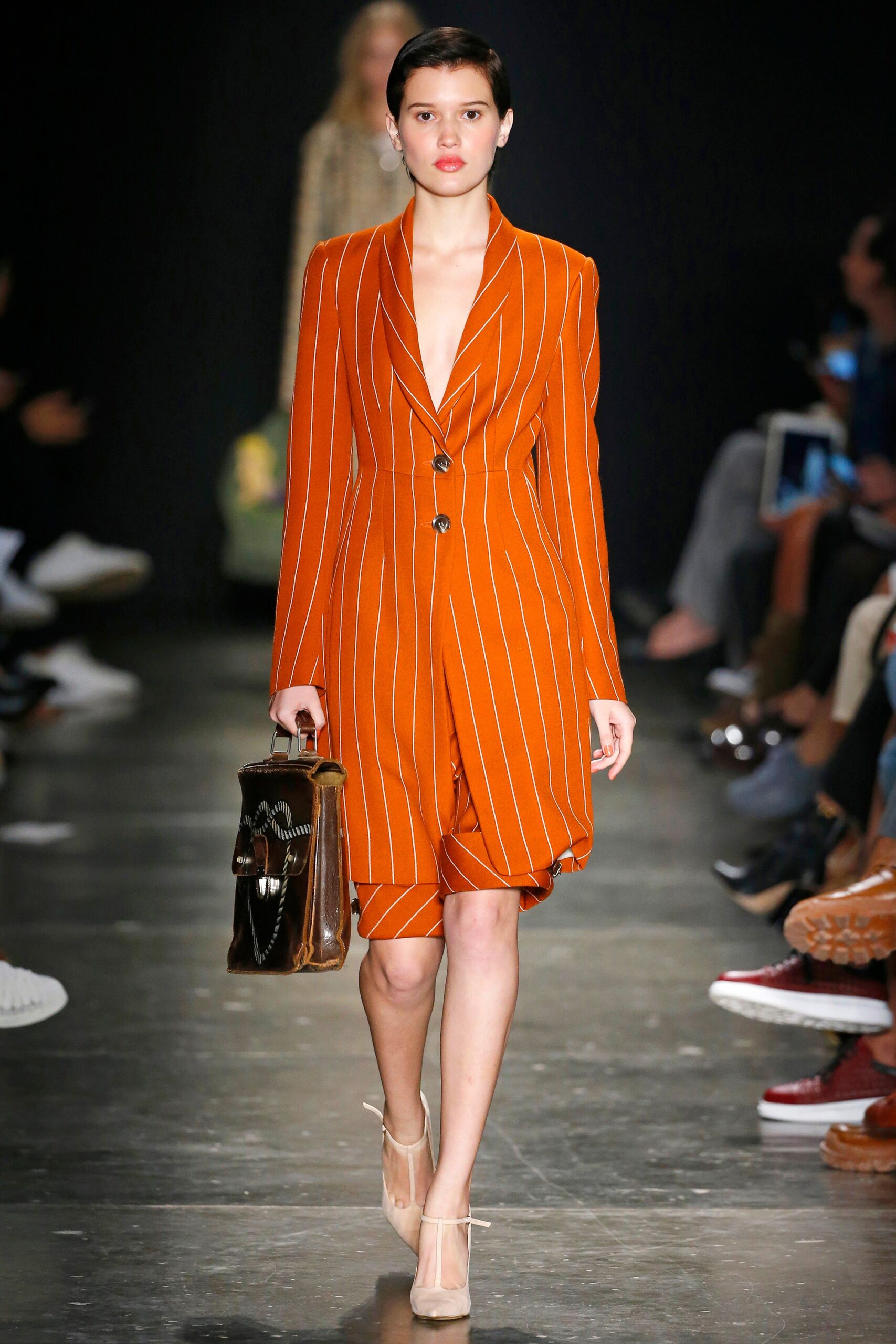 A fitted orange striped dress with a V-neckline and long sleeves.