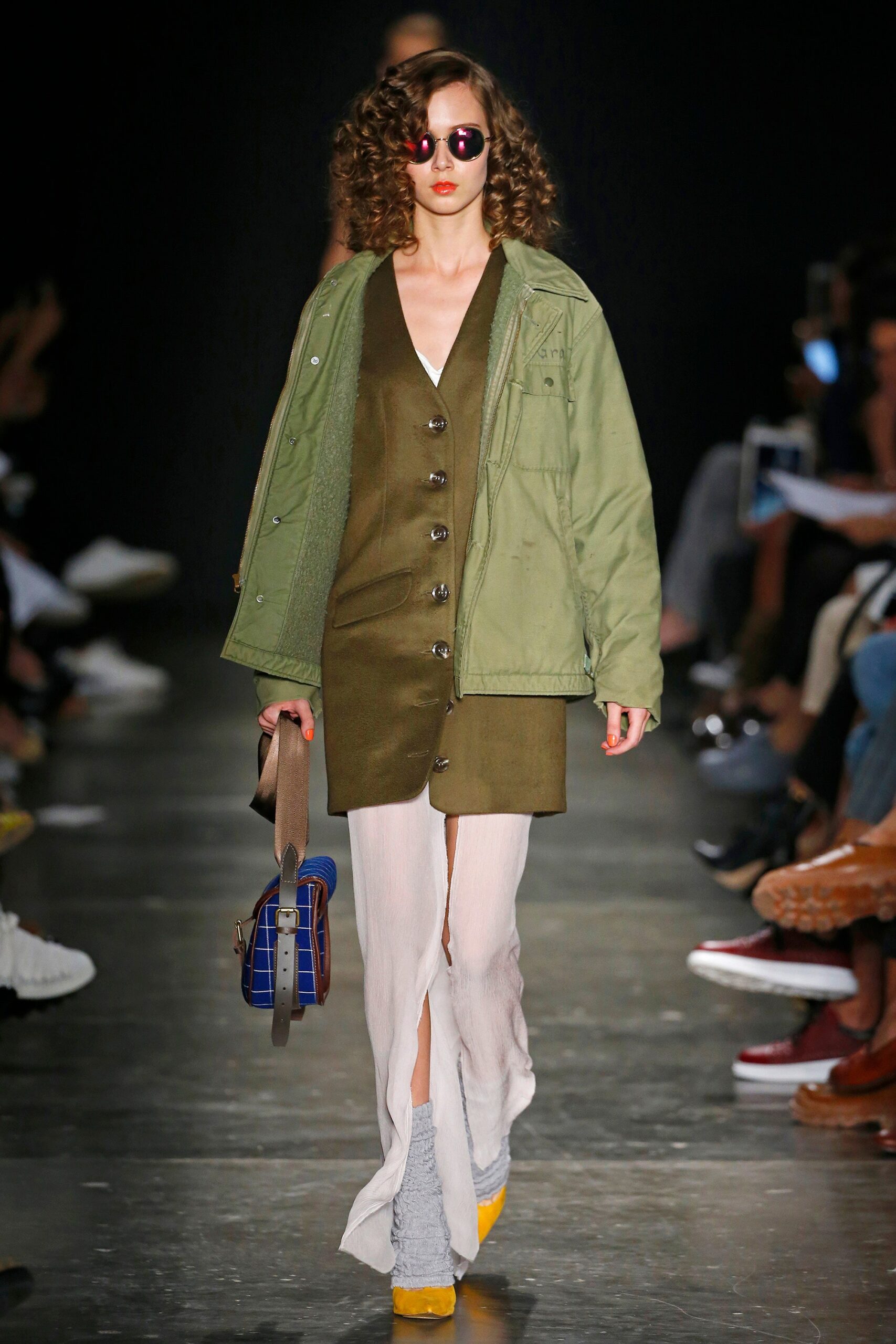 A relaxed green cotton dress with a collared neckline and buttoned details, layered with a jacket.