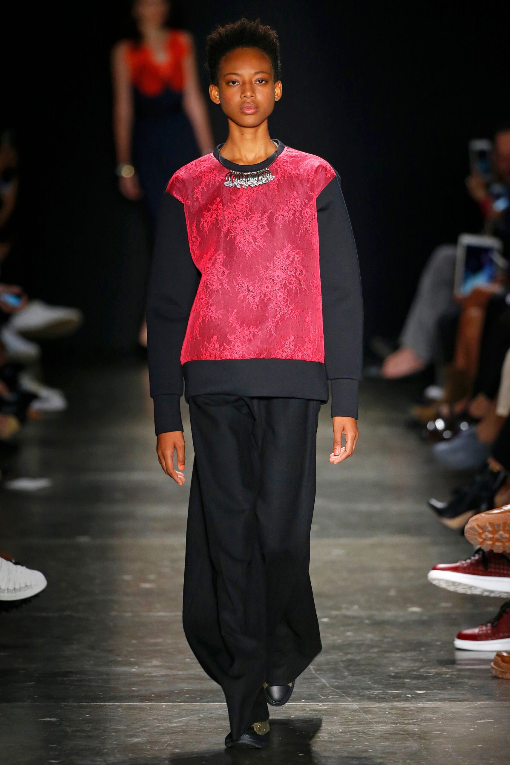 A relaxed black and red printed top paired with loose-fitting pants.