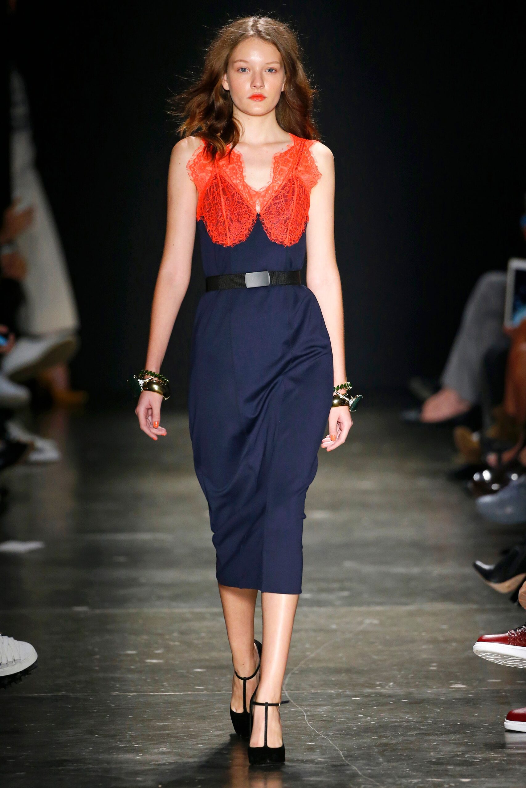 A fitted navy silk sleeveless dress with a V-neckline and tiered design details.