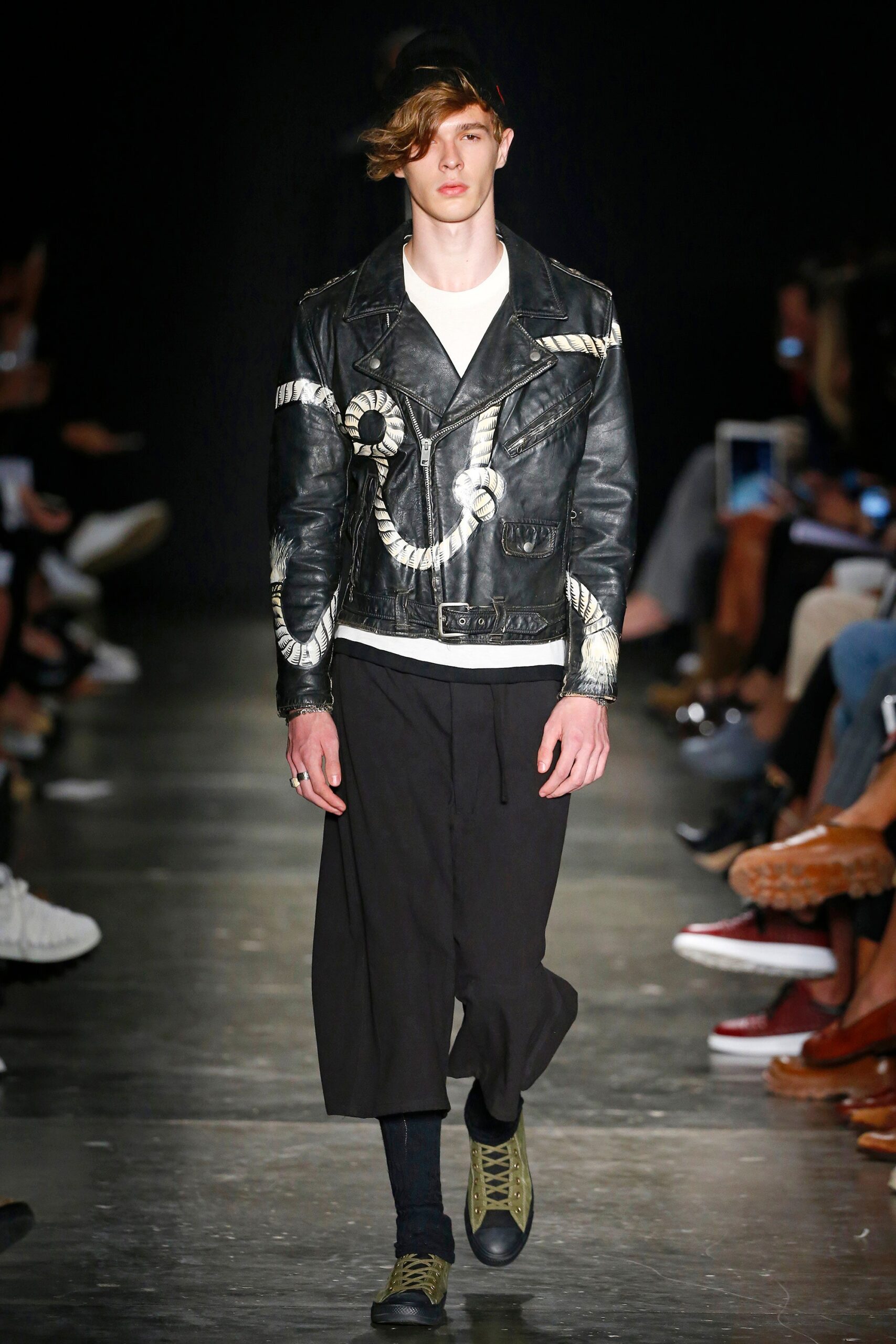 A relaxed black leather jacket with a collared neckline paired with relaxed-fit pants.