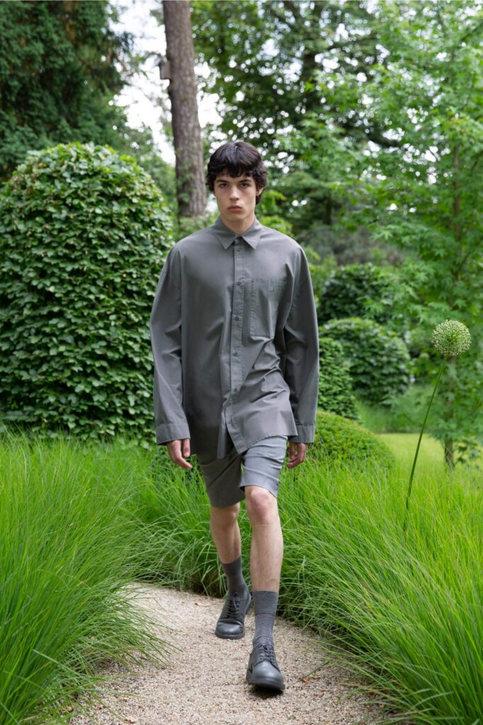 A relaxed gray cotton shirt with long sleeves and collared design paired with matching shorts.