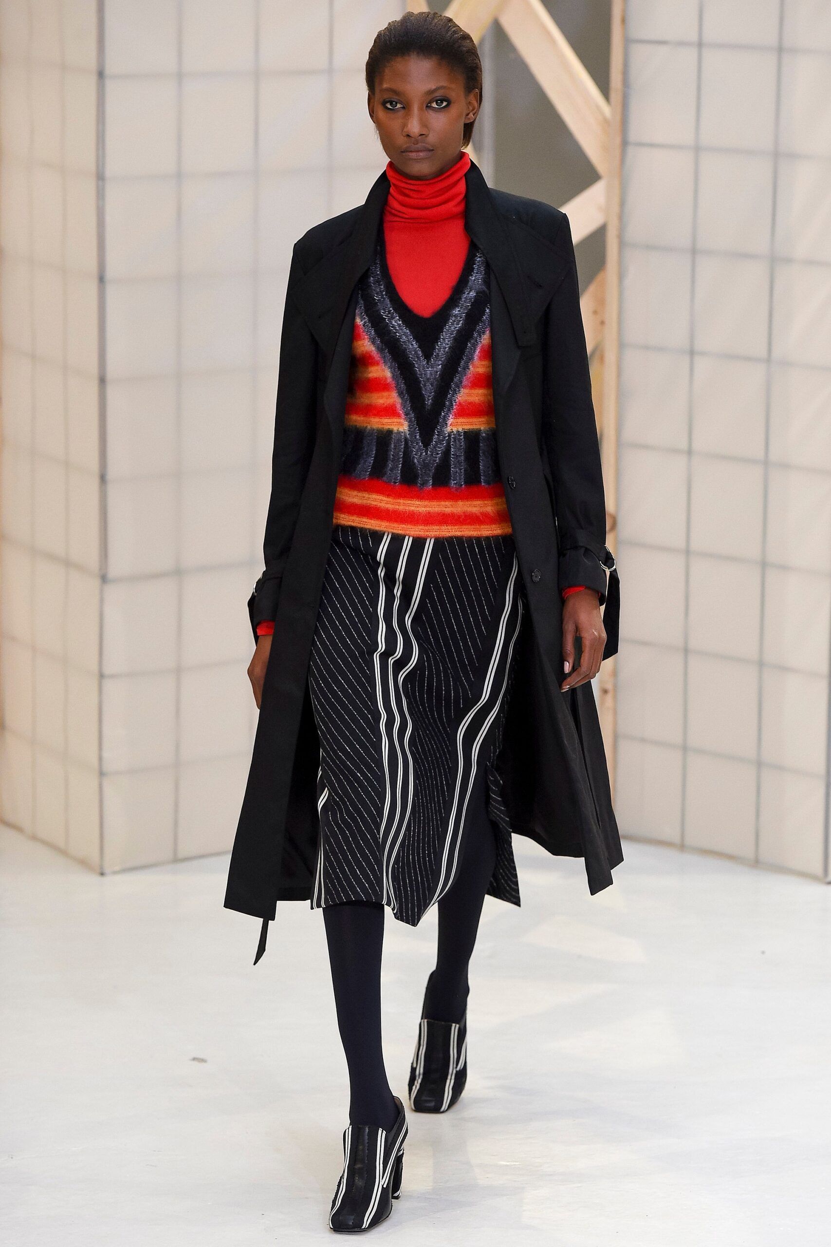 black coat with striped sweater and midi skirt