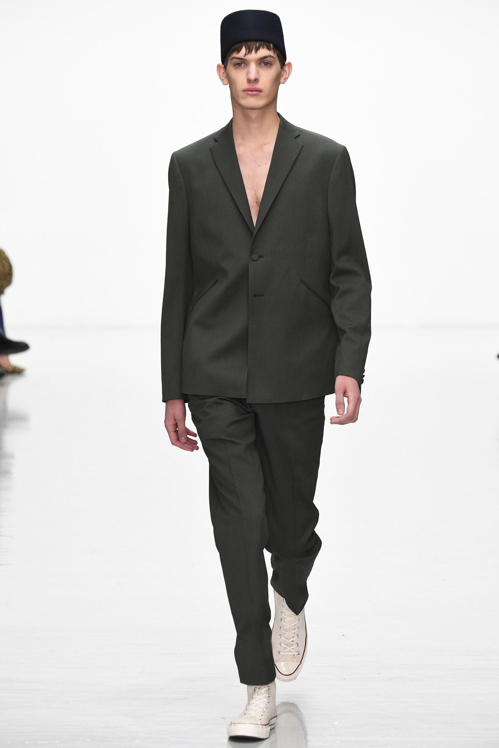 green tailored suit with white shoes