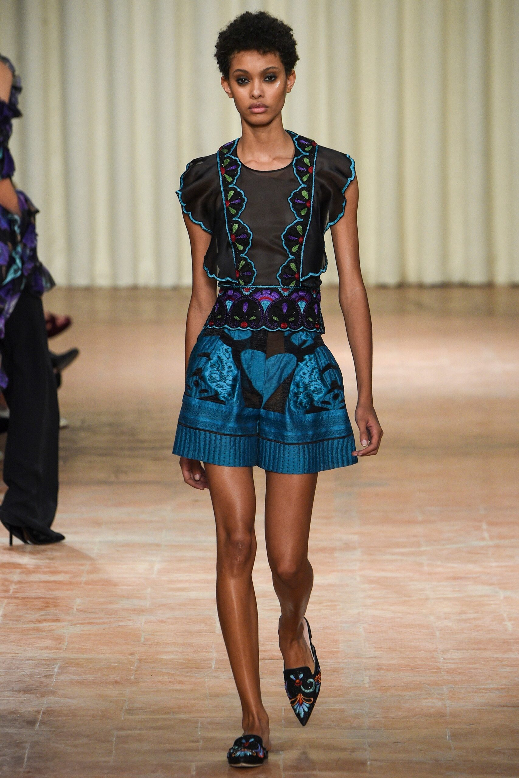 black silk ruffled top with blue shorts
