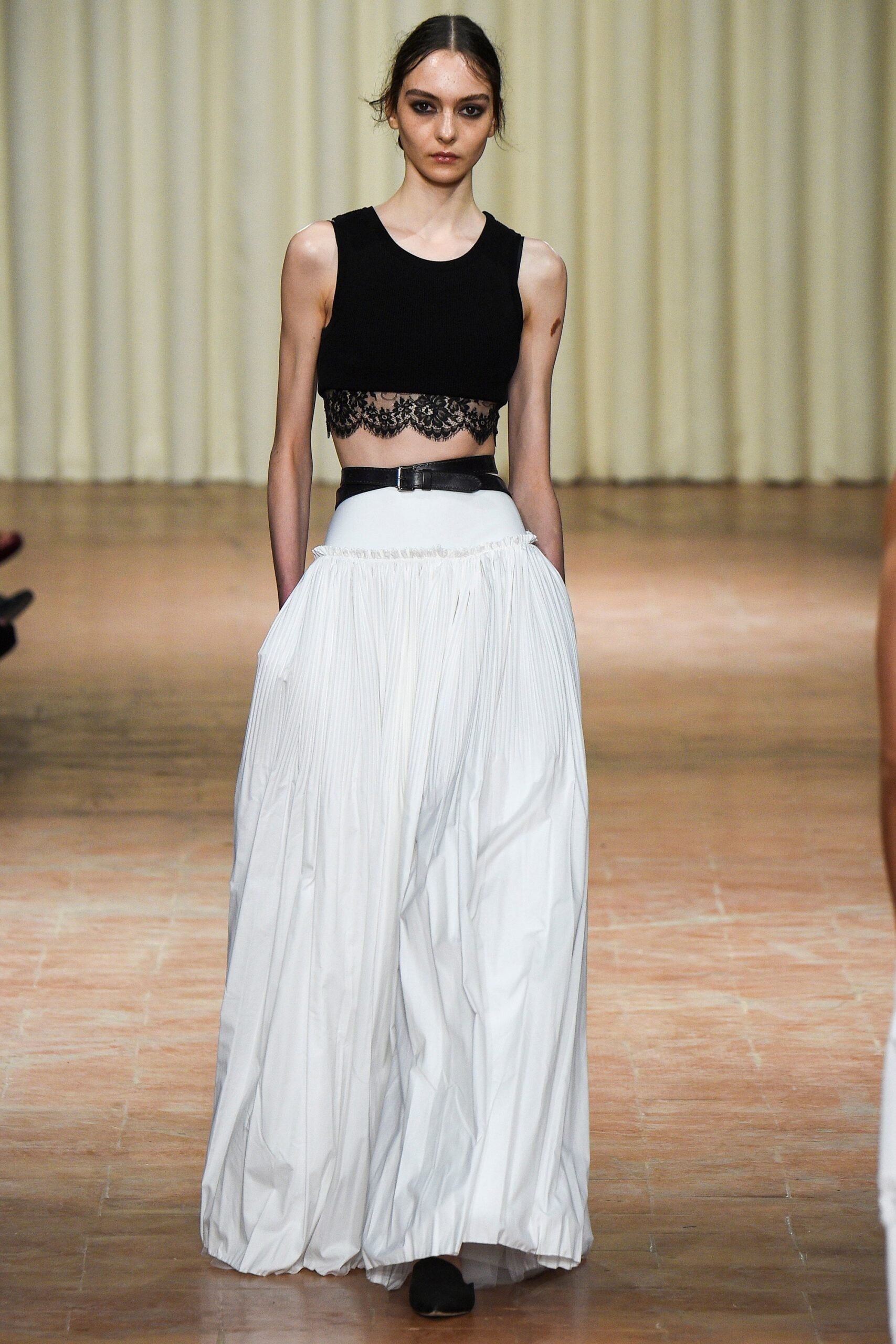 black fitted top and white pleated skirt