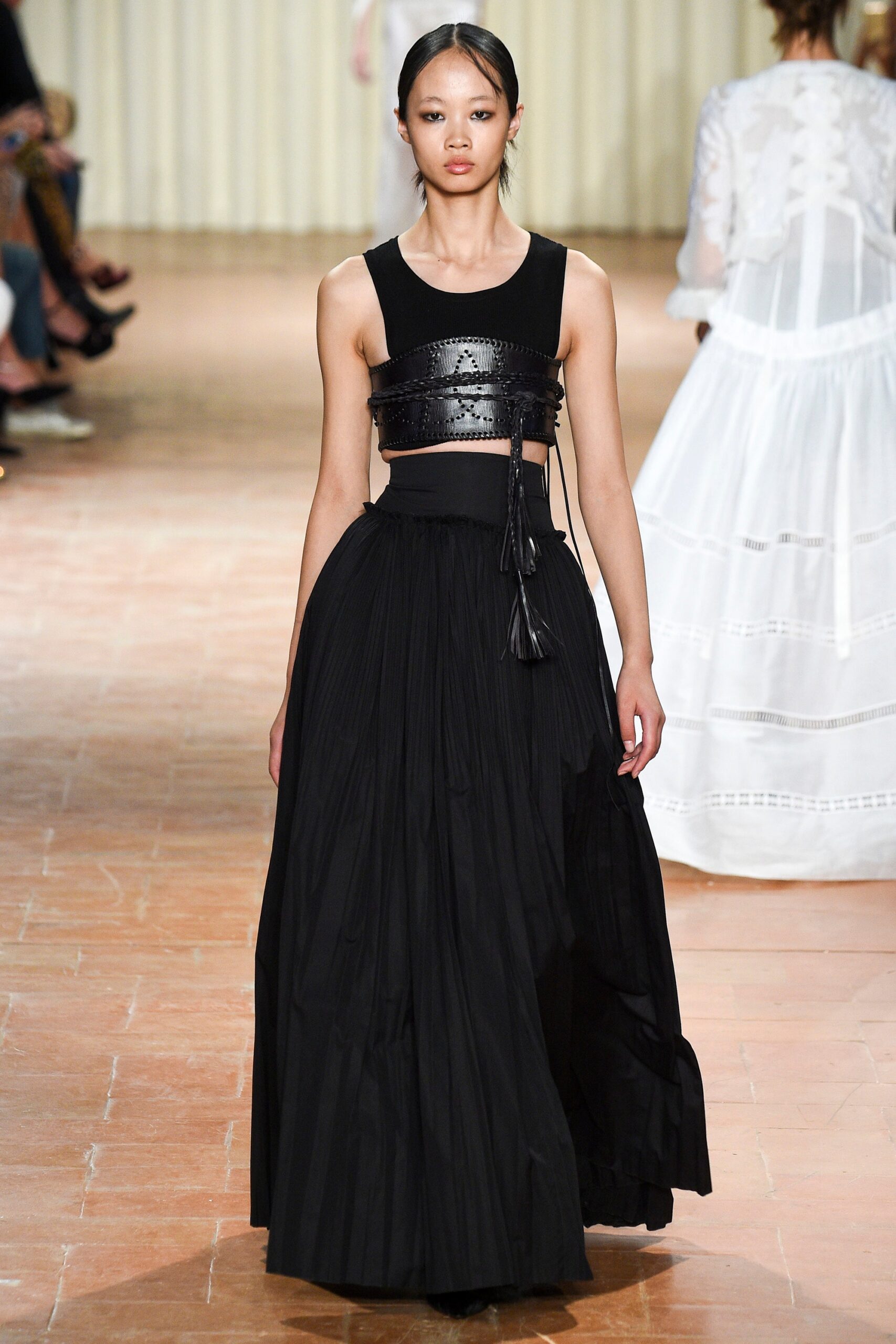 black leather crop-top and pleated skirt