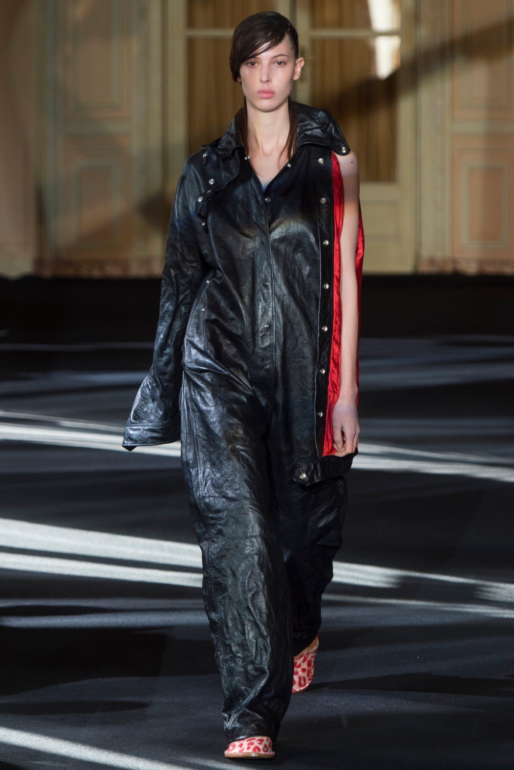 black leather fitted jumpsuit with red cape