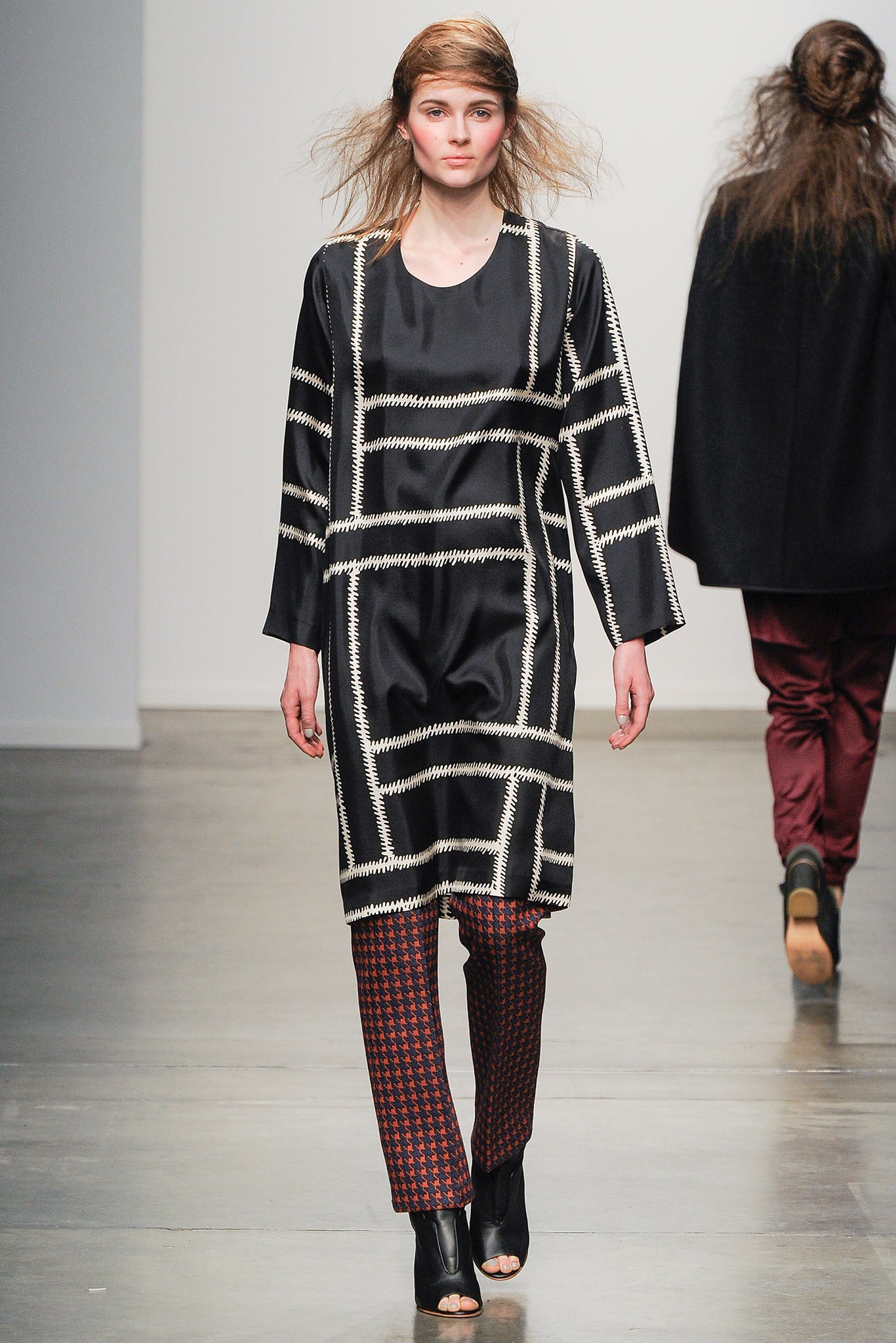 A relaxed black silk dress with a printed design, paired with red patterned pants.