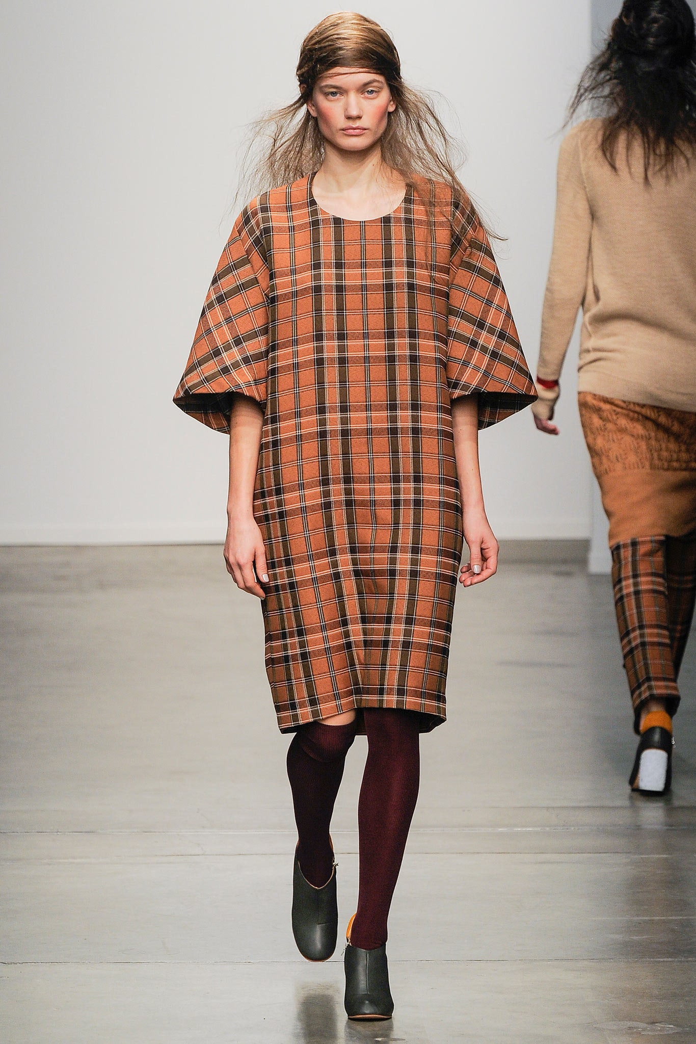 A relaxed brown and orange checked dress with short sleeves and a collared neckline.
